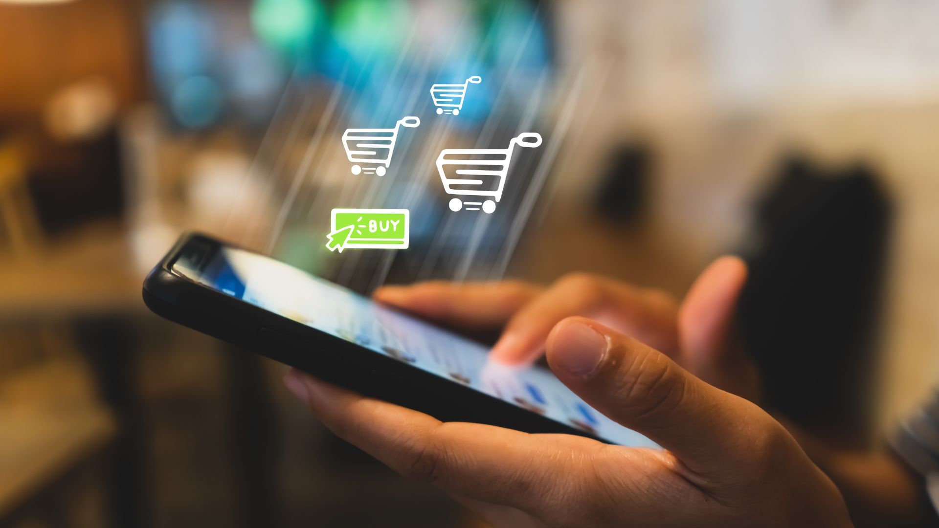 Close-up of a person holding a phone with animated shopping cart icons and a glowing “buy” button overlay.