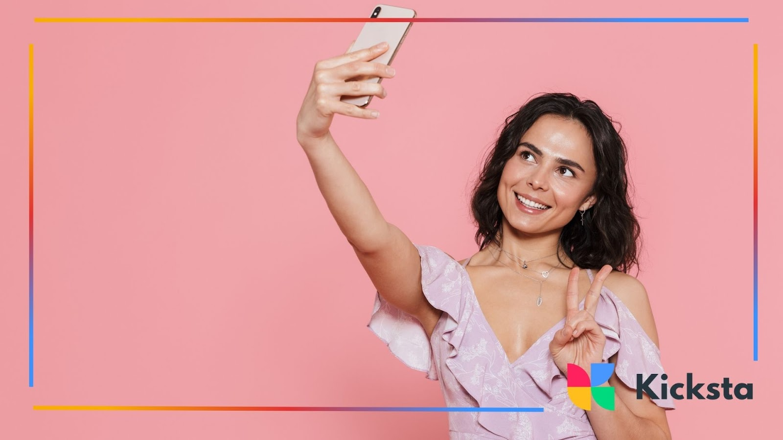 Woman in pink taking a selfie with a peace sign