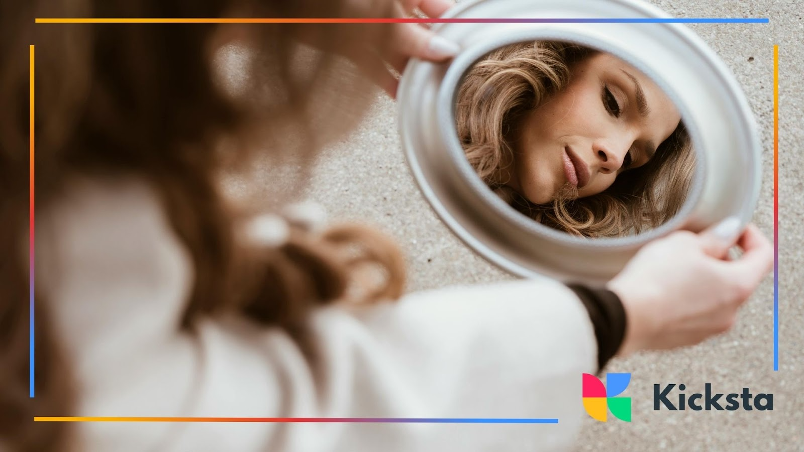 A woman stares into her reflection in a small round mirror