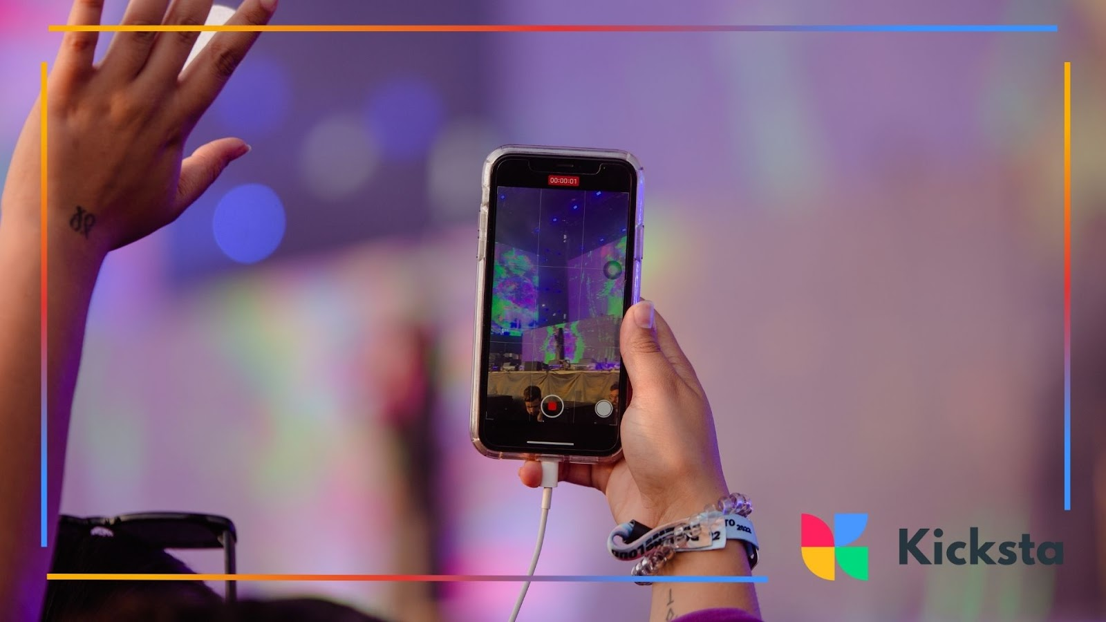 Person holding up a phone at a concert, live streaming the event.