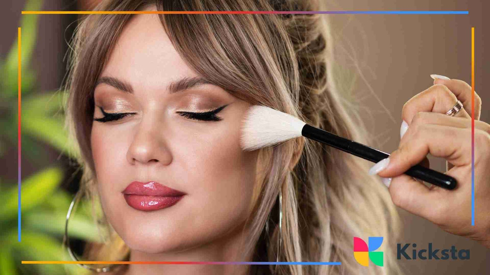 Makeup artist applying highlighter with a brush.