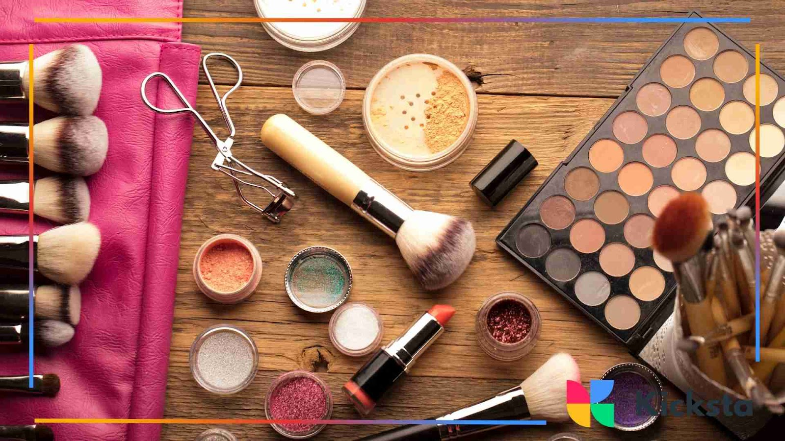 Flat lay of makeup products including brushes, palettes, and lipstick.