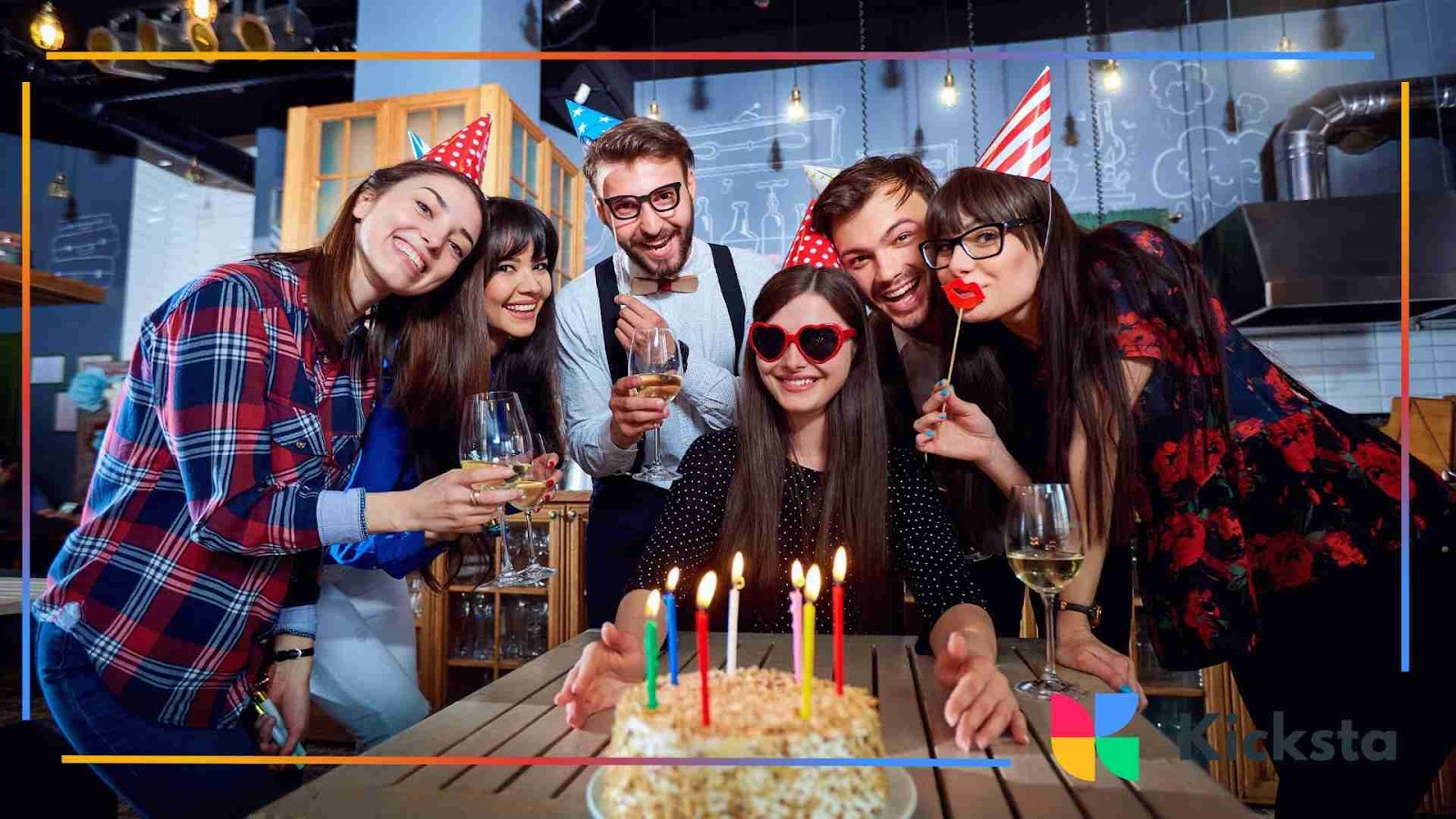 Cheerful group of friends celebrating a birthday with cake and candles.