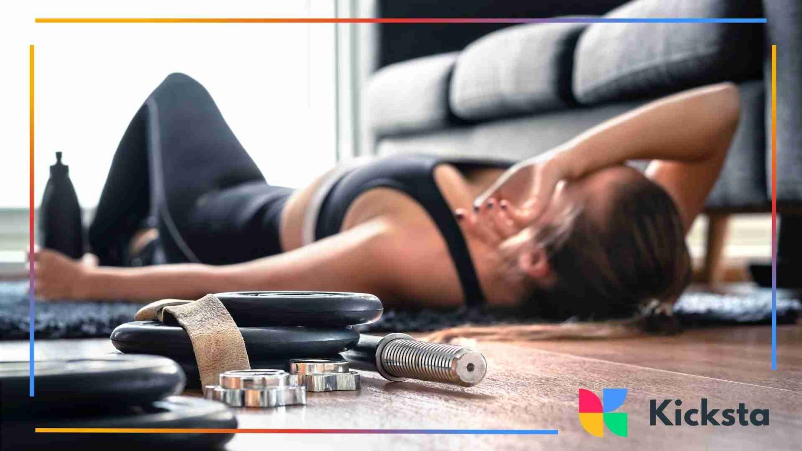 Woman lying on the floor, tired post-workout, with weights in the foreground