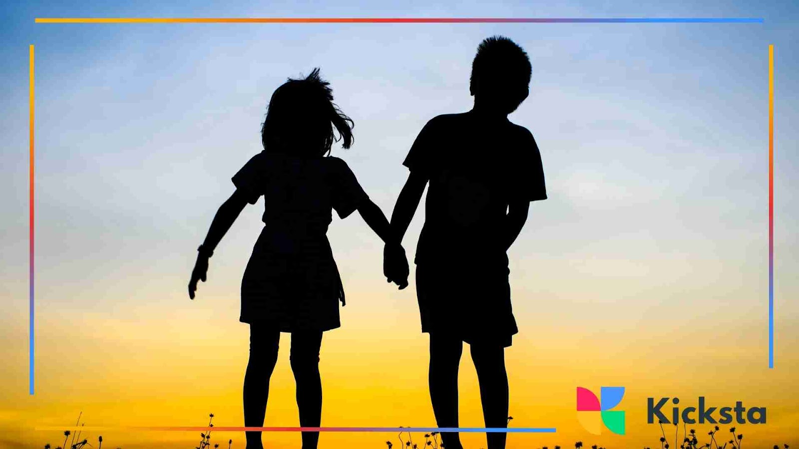 Silhouette of a young brother and sister holding hands at sunset