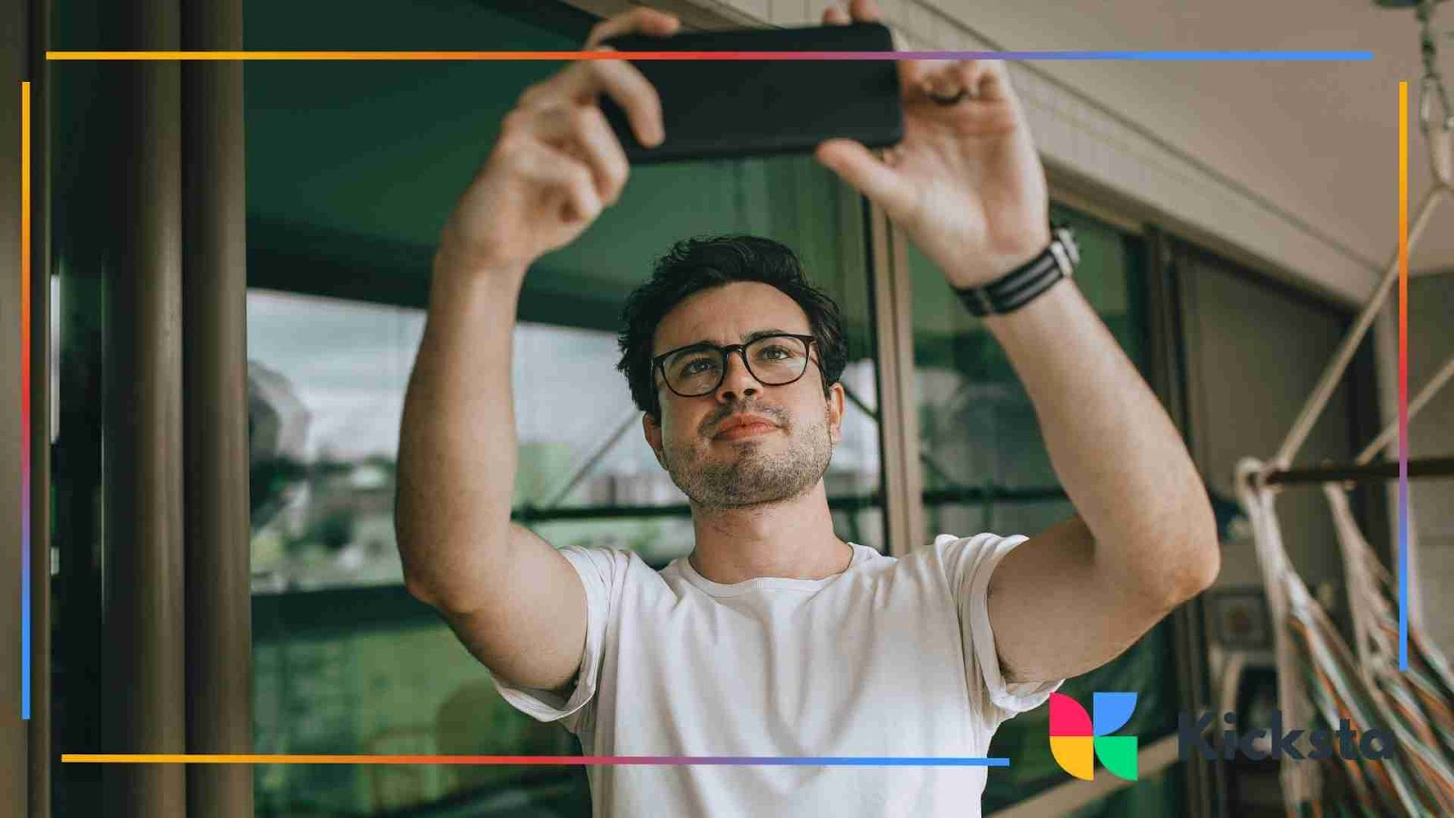 Man in glasses taking a selfie with his phone