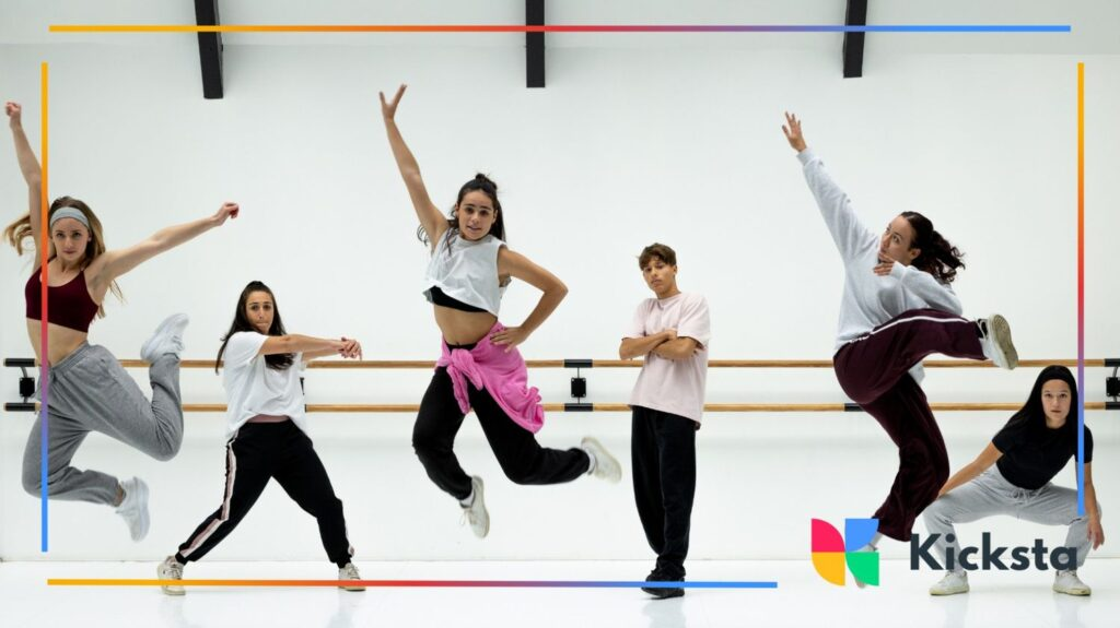 Group of young dancers in a studio jumping mid-air during a hip-hop routine.