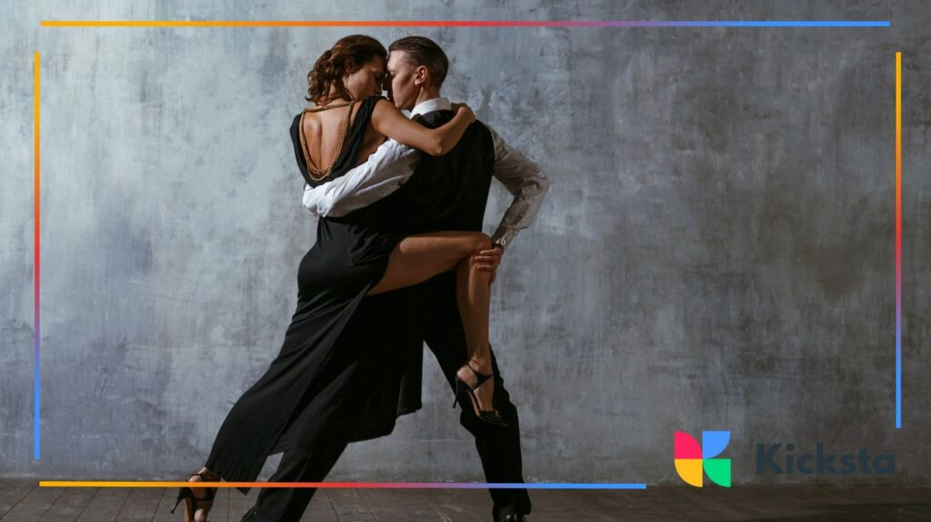 Couple performing an elegant tango in a dimly lit studio.
