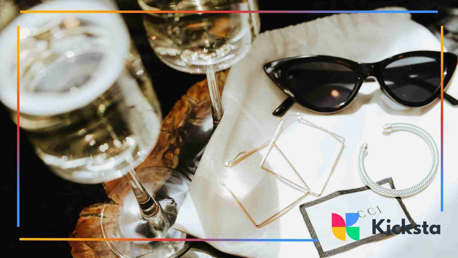 Classy black sunglasses and jewelry styled with champagne glasses
