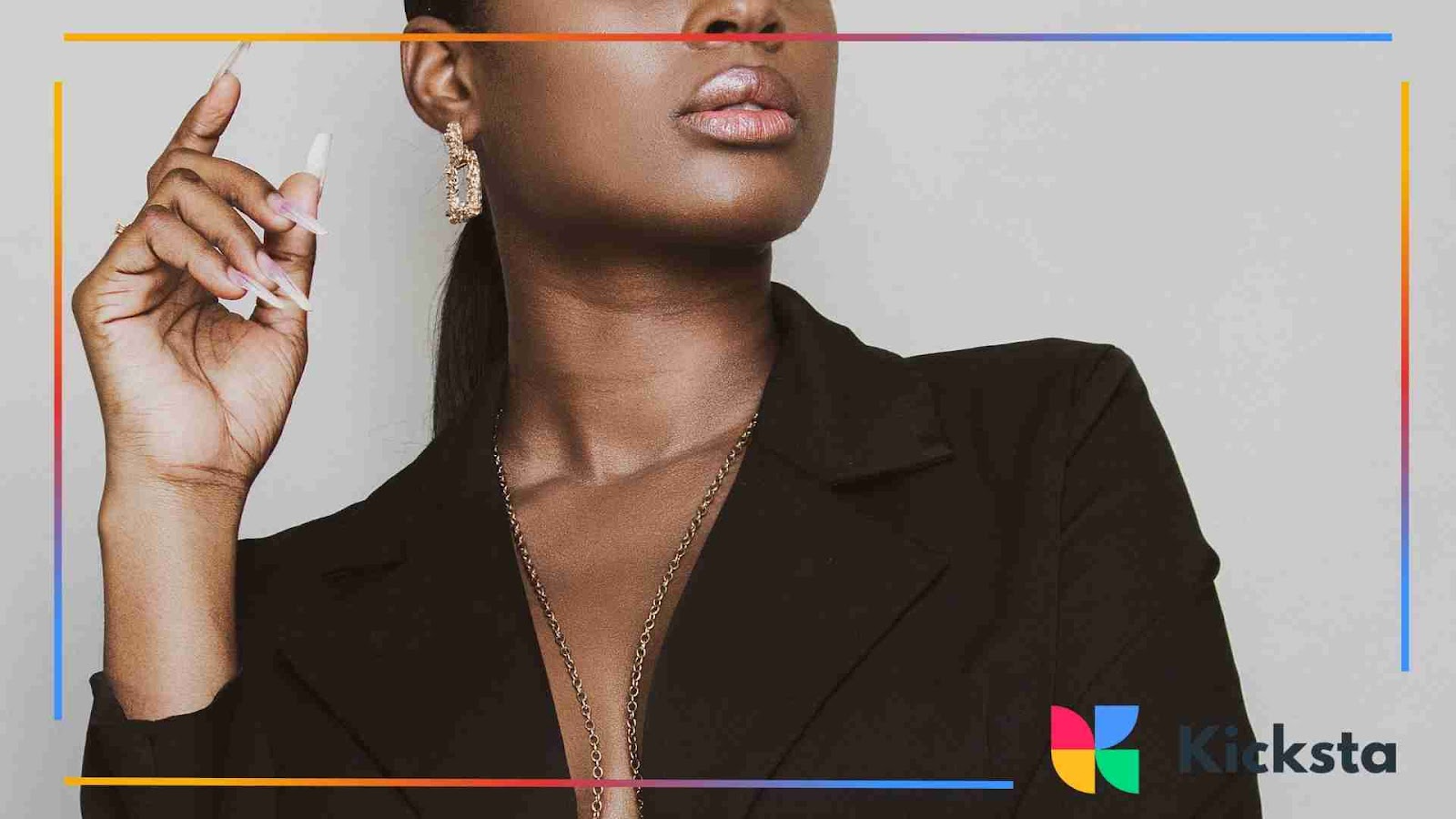 Classy woman in a black blazer showcasing bold earrings and polished nails