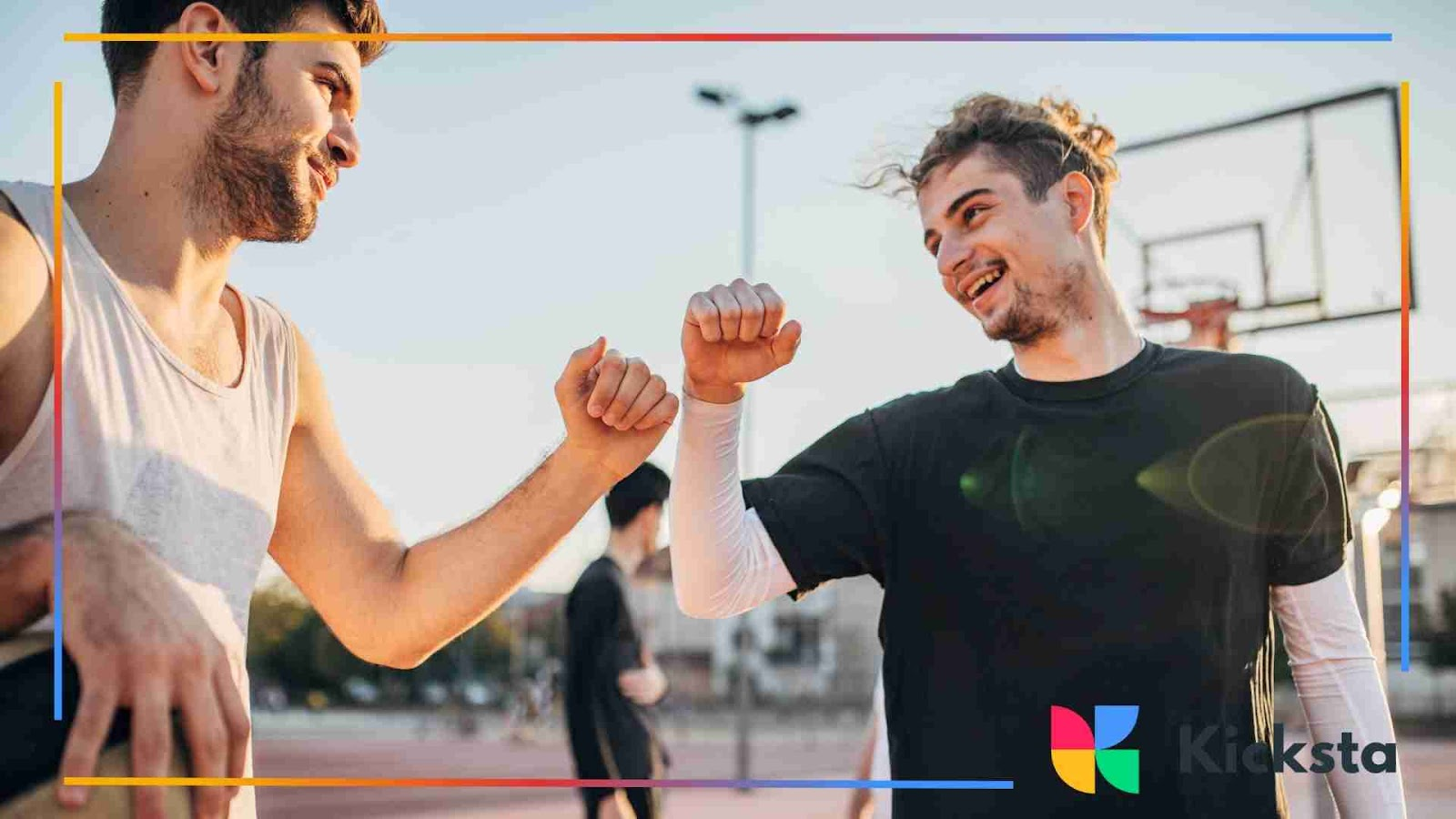 Two men on a basketball court bumping elbows and laughing after a game.