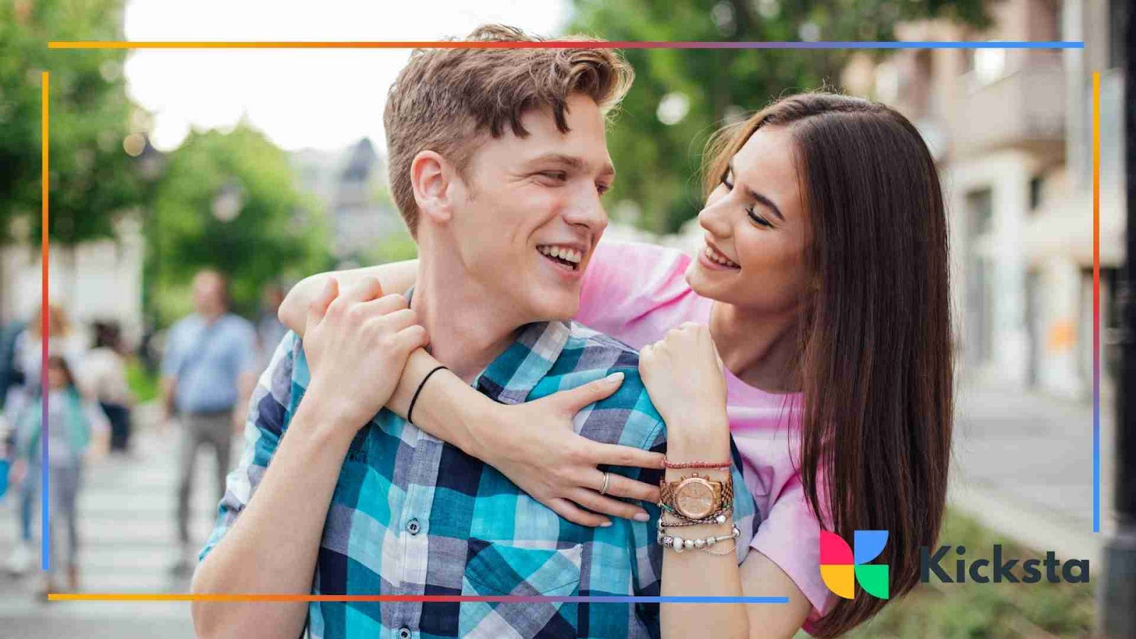 A cheerful couple smiling and embracing on a city street