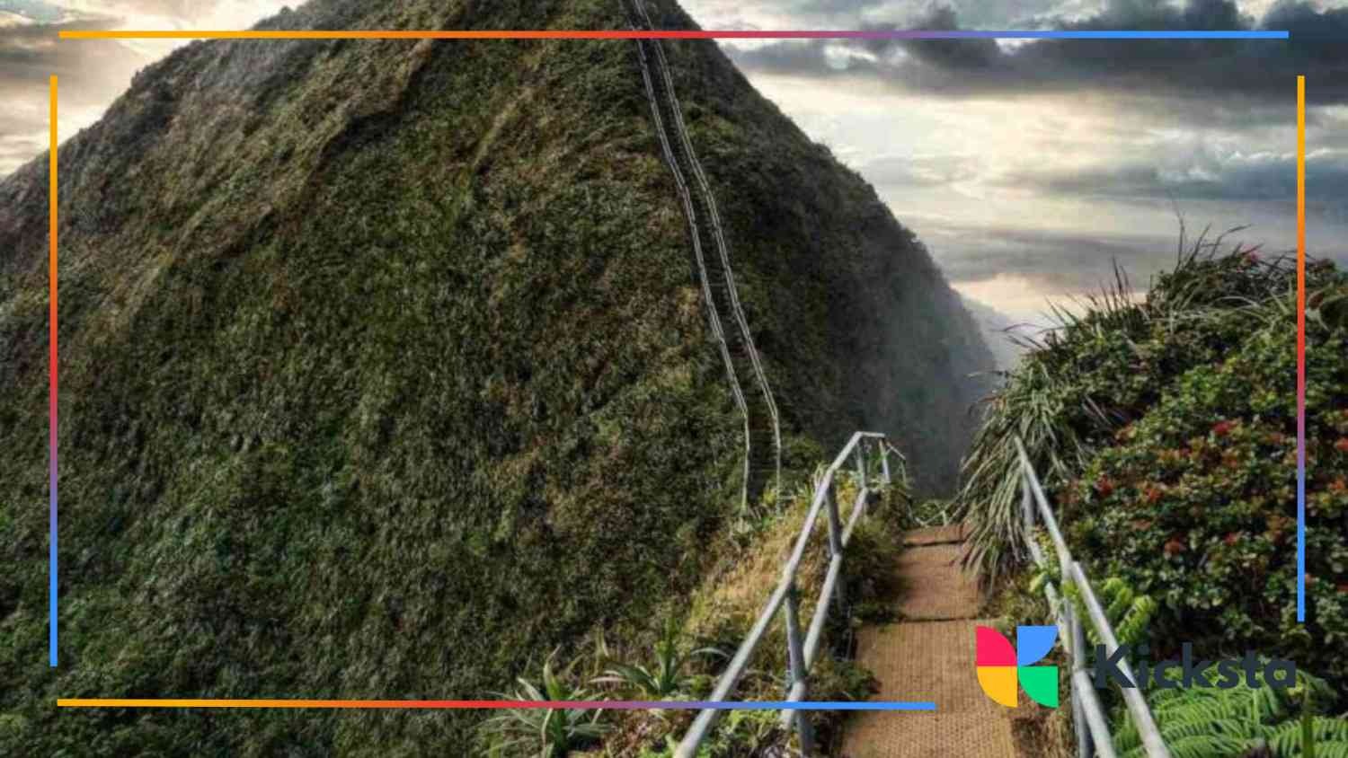 Steep hiking trail known as the Haiku Stairs or Stairway to Heaven in Hawaii, surrounded by lush green mountains and clouds.