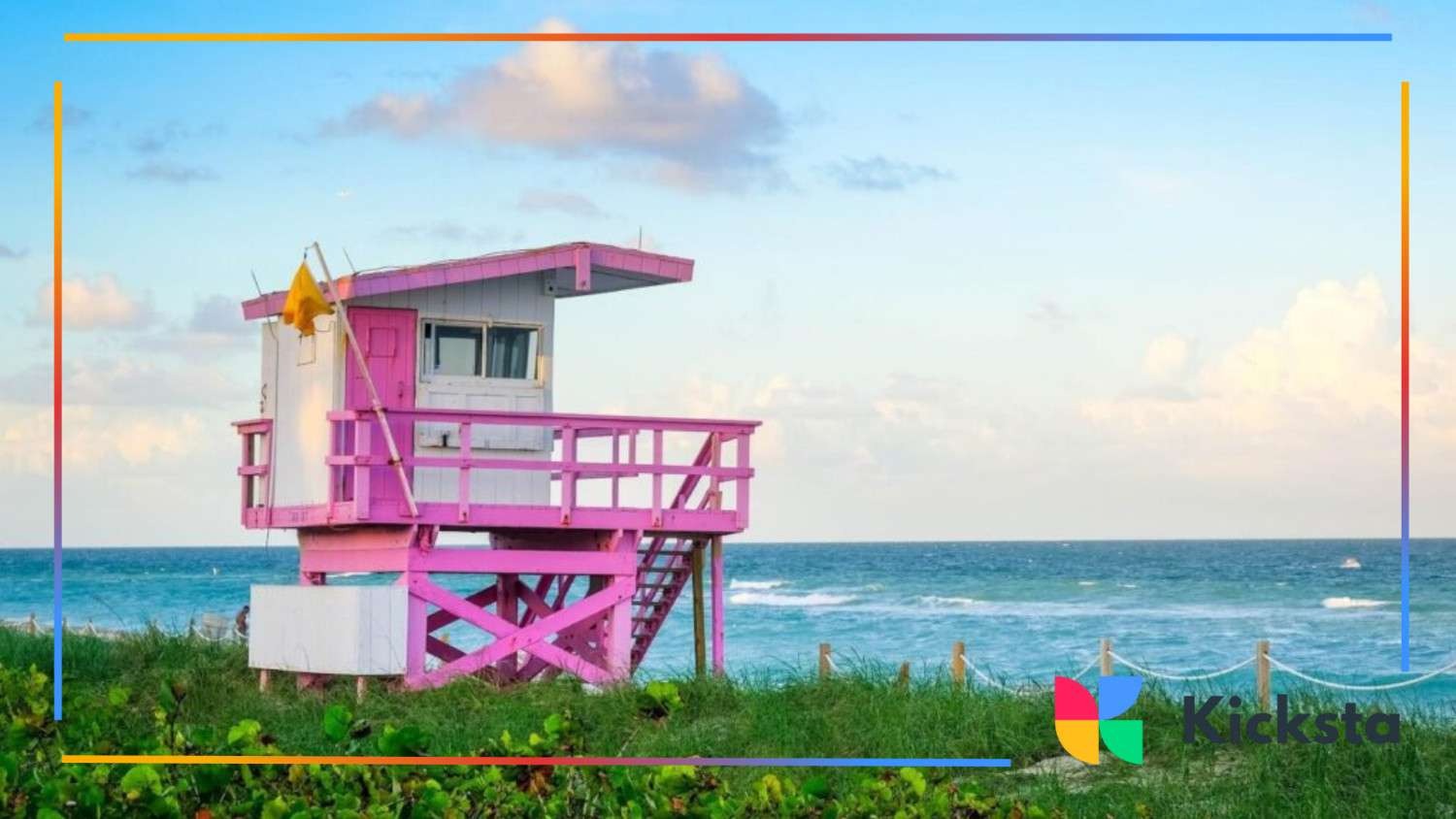 Bright pink lifeguard tower overlooking a blue ocean and sky on a sunny day.