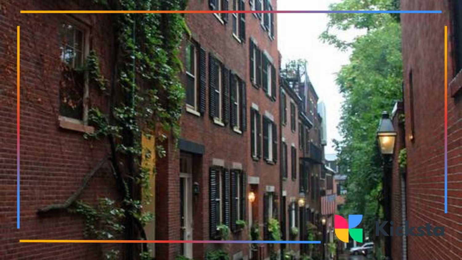 Narrow brick alleyway with historic buildings, black shutters, and greenery along the walls