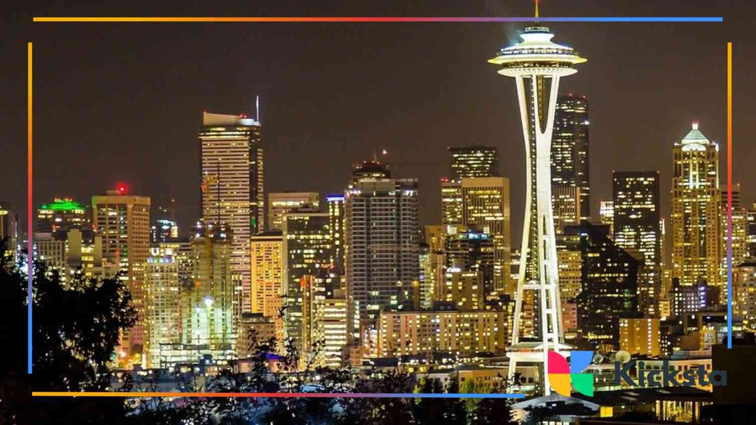 Night view of a brightly lit city skyline featuring the Space Needle against a dark sky