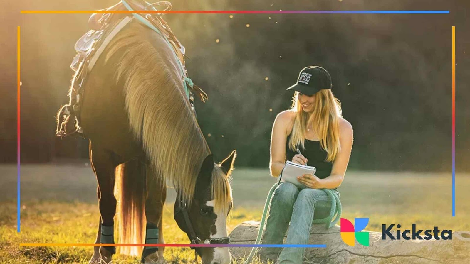 Woman sitting in sunlight writing in a notebook beside a brown horse grazing on grass, both bathed in a warm golden glow