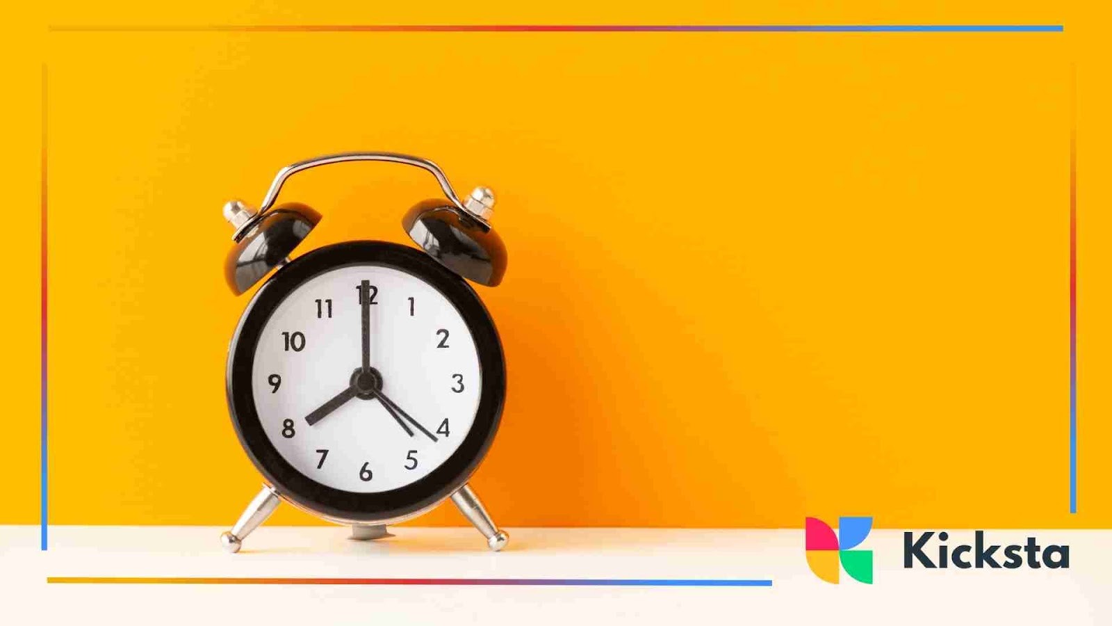 A classic black alarm clock on a bright yellow background