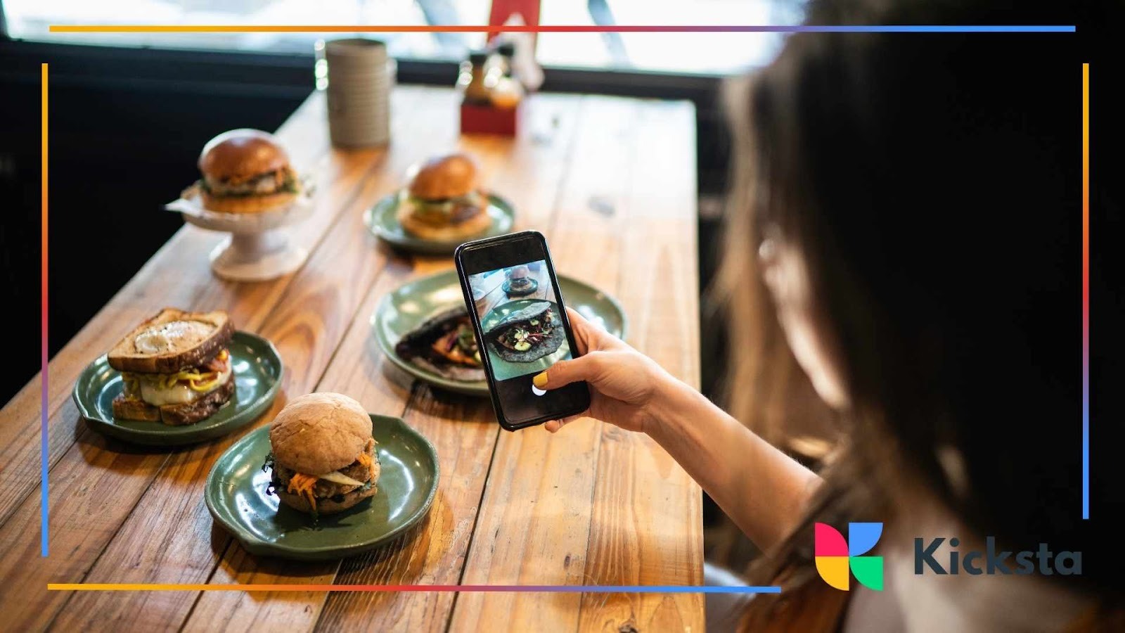 Food blogger photographing gourmet burgers in restaurant for Instagram food photography and content marketing.