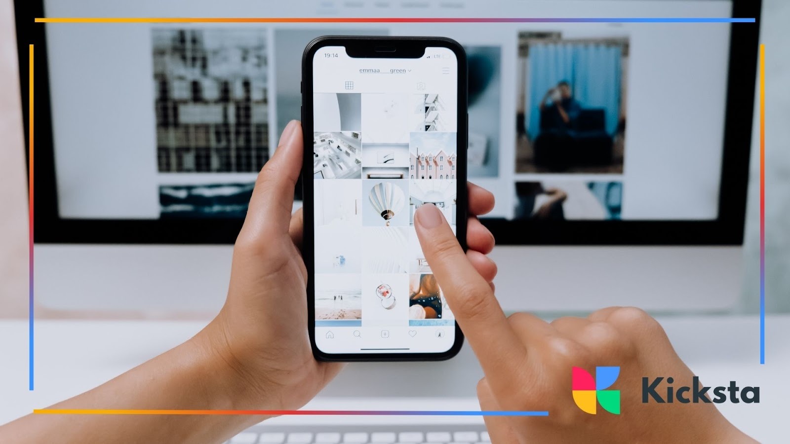 Person using smartphone to browse image gallery in front of desktop computer, representing social media content creation, digital marketing, and online engagement.