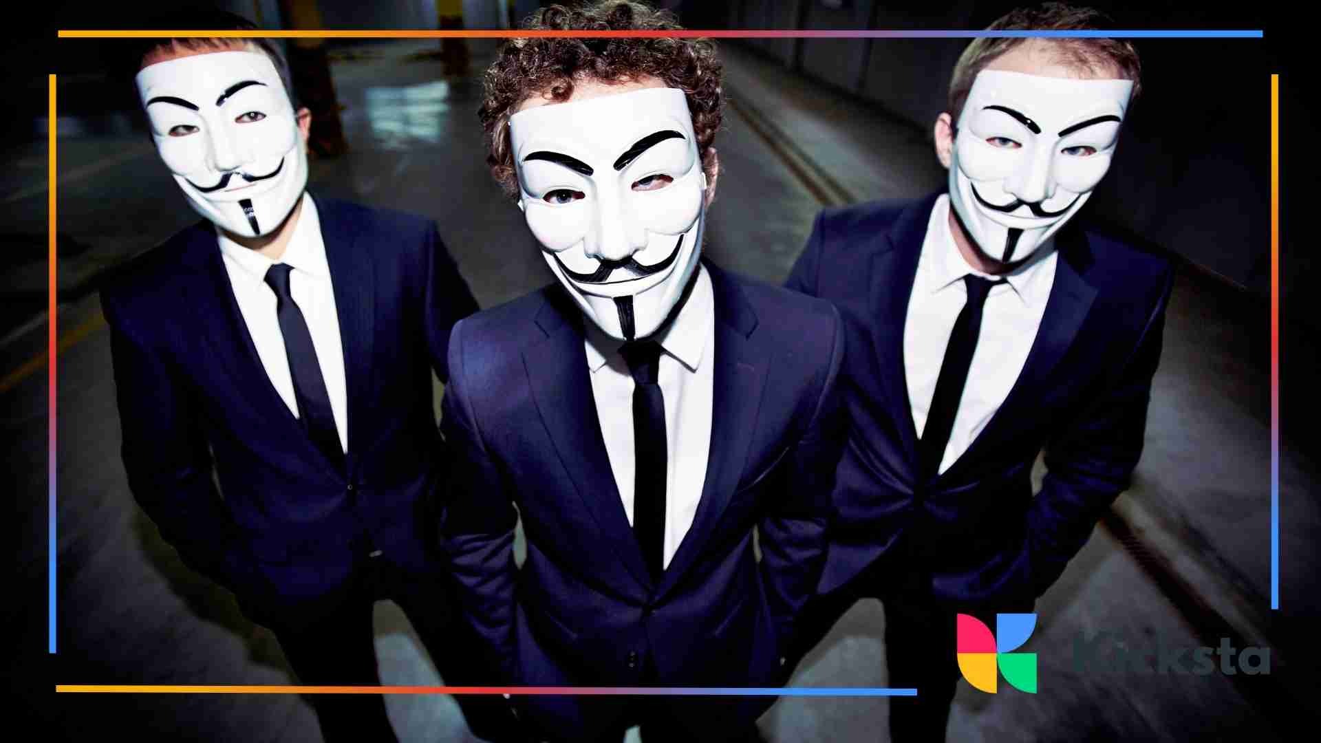 Three people in suits wearing Guy Fawkes masks standing together.