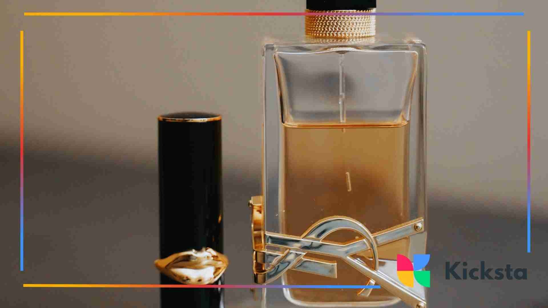 Close-up of a luxury perfume bottle and lipstick on a reflective surface.