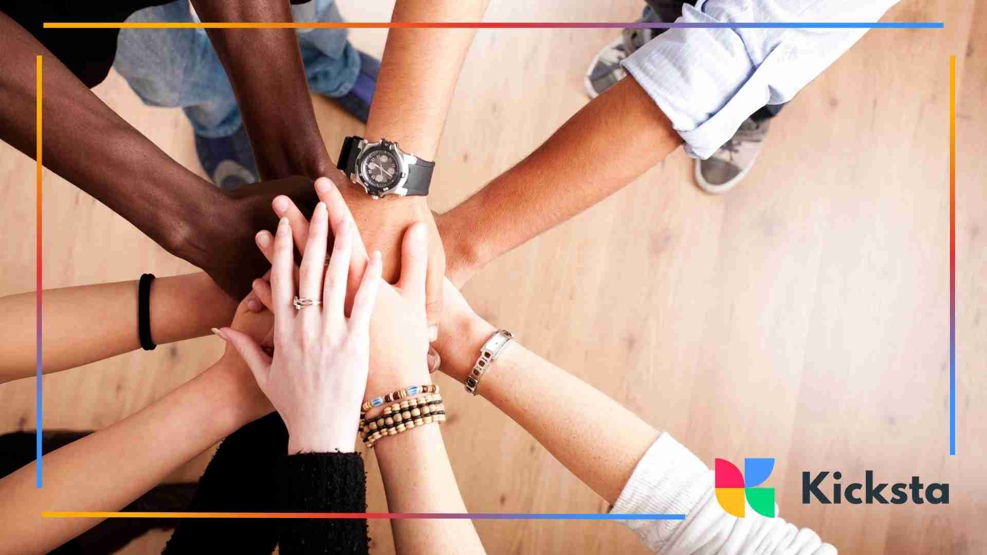 Group of diverse hands stacked together in a teamwork gesture.