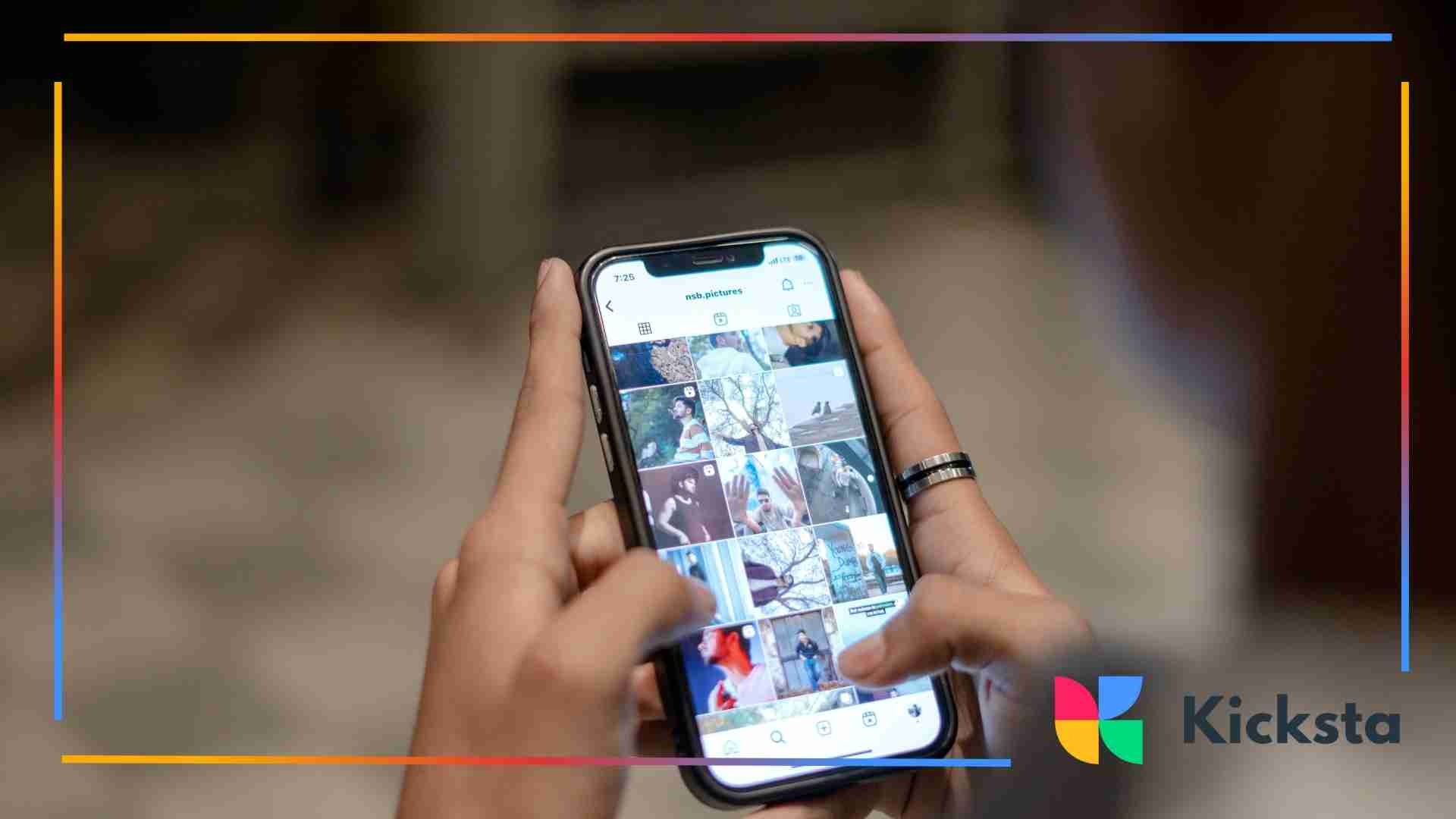 Close-up of hands holding a smartphone while scrolling through a grid-style photo gallery on Instagram.