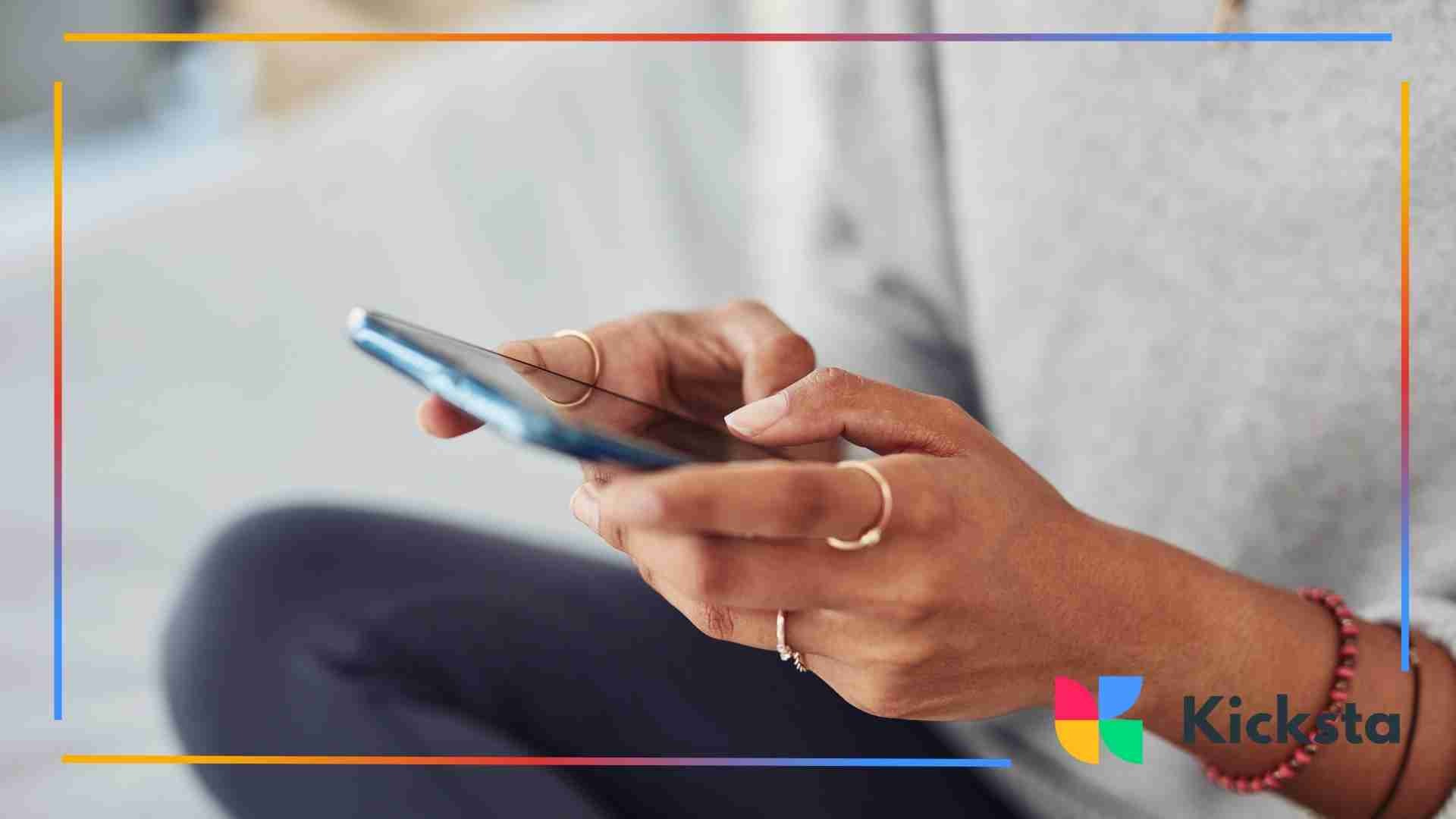 Close-up of a person holding a smartphone and scrolling with both hands.
