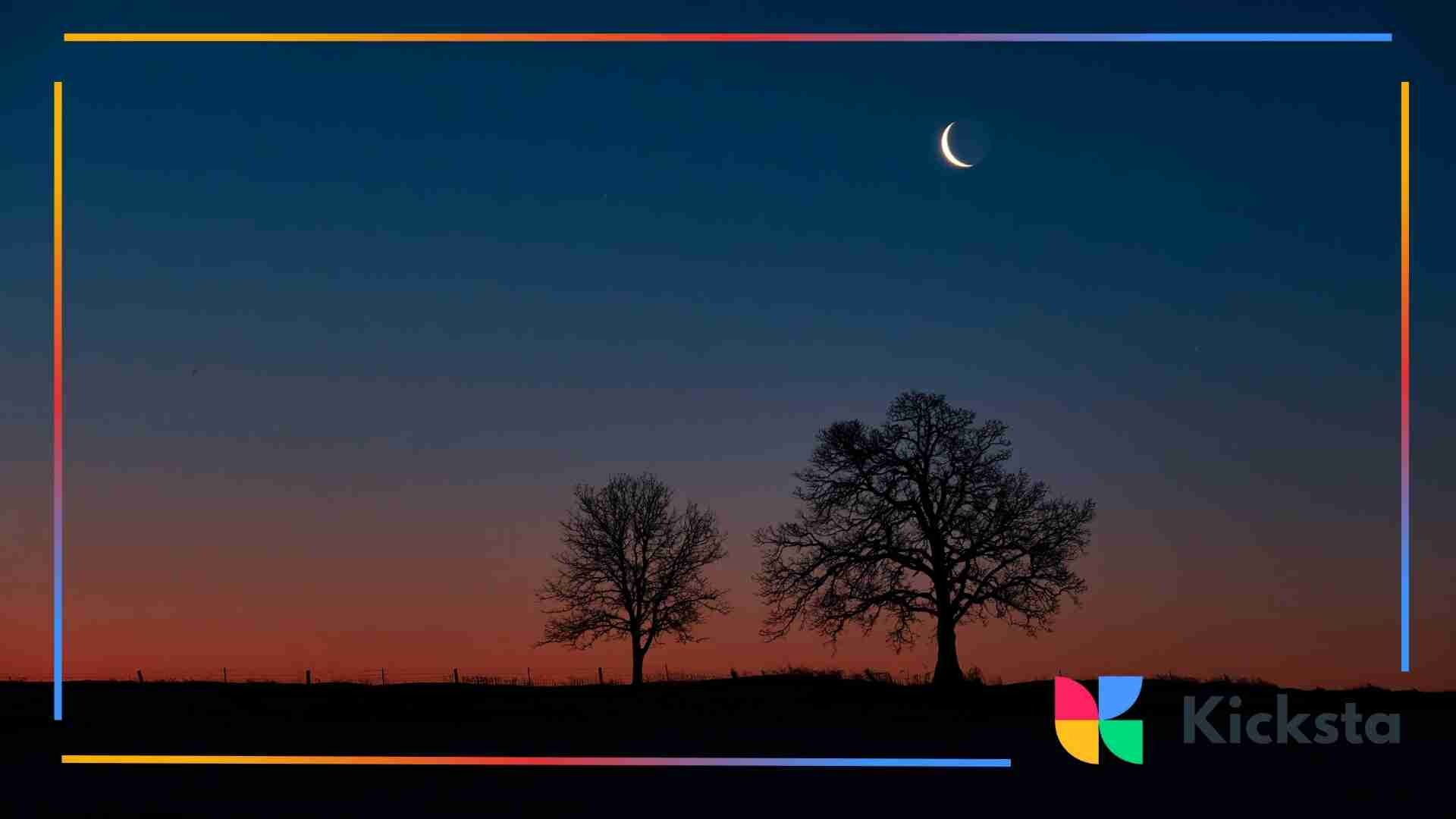 Two bare trees under a twilight sky with a thin crescent moon overhead.