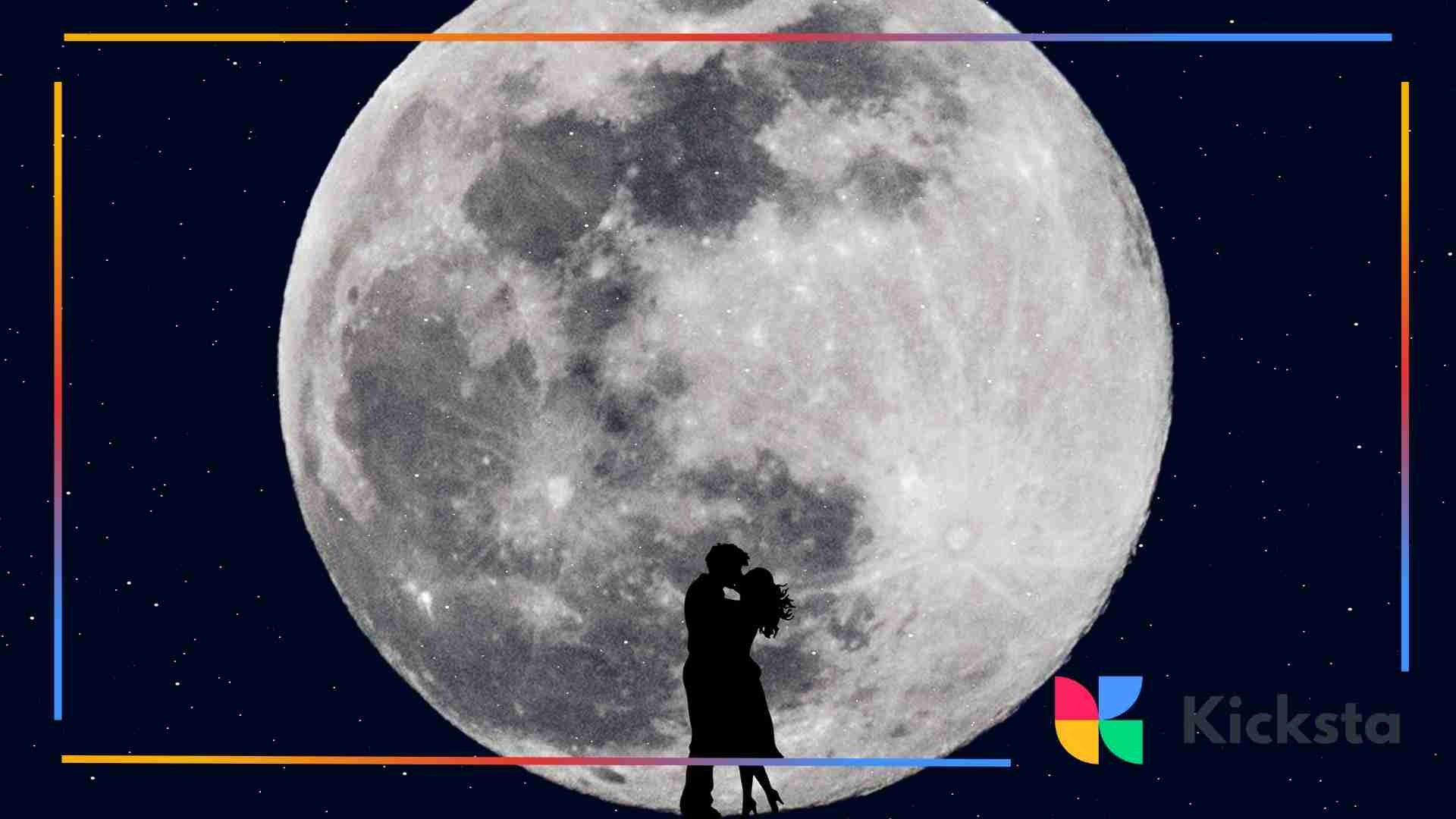 Silhouetted couple embracing in front of a giant full moon in a starry night sky.