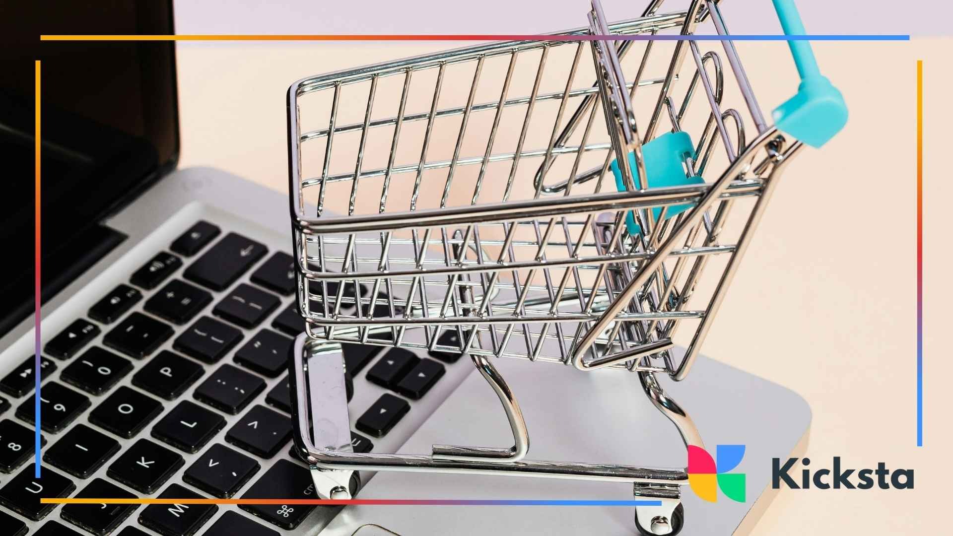 Small metal shopping cart placed on top of a laptop keyboard, representing online shopping or e-commerce.