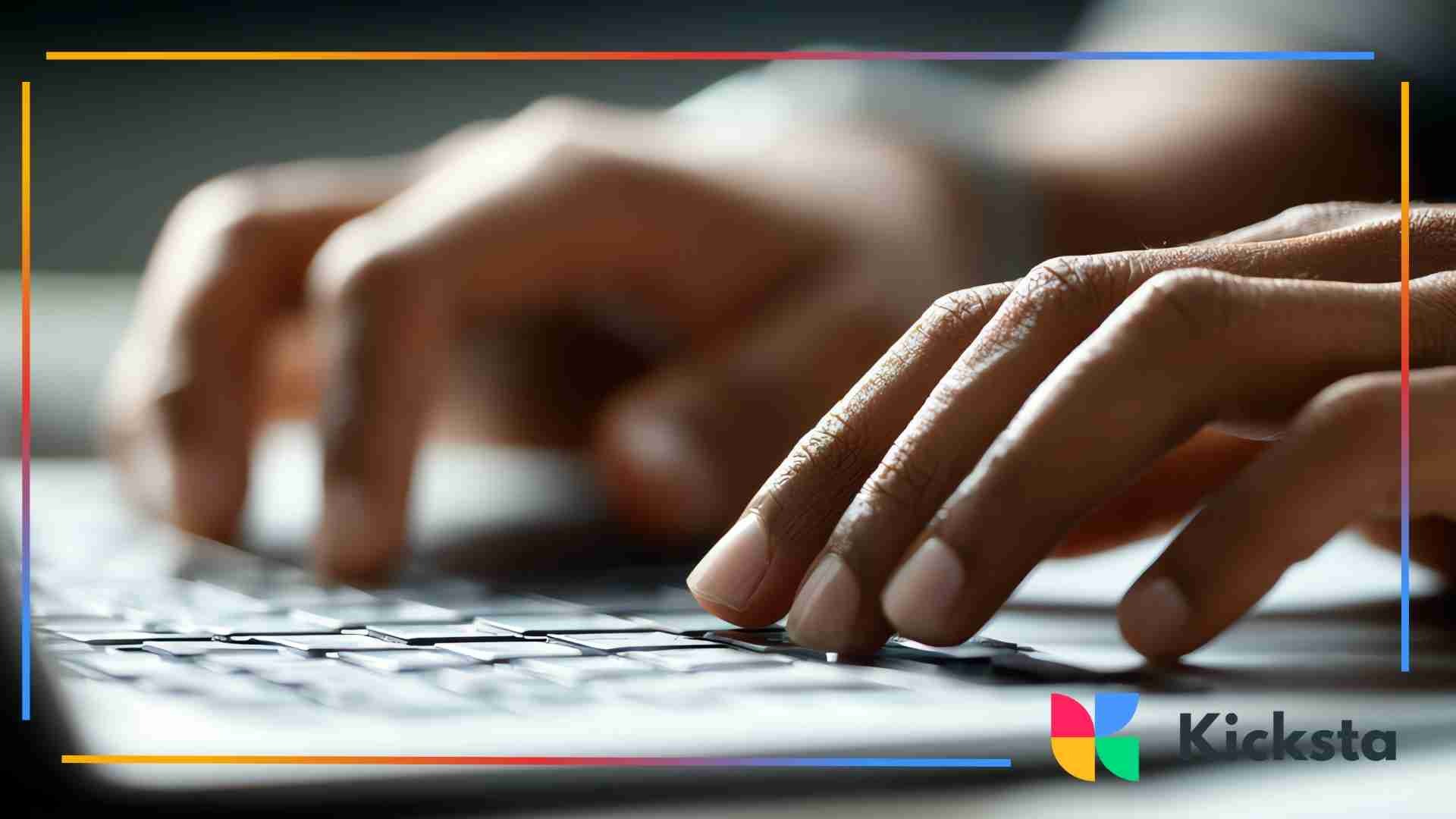 Close-up of hands typing on a laptop keyboard in a dimly lit environment.