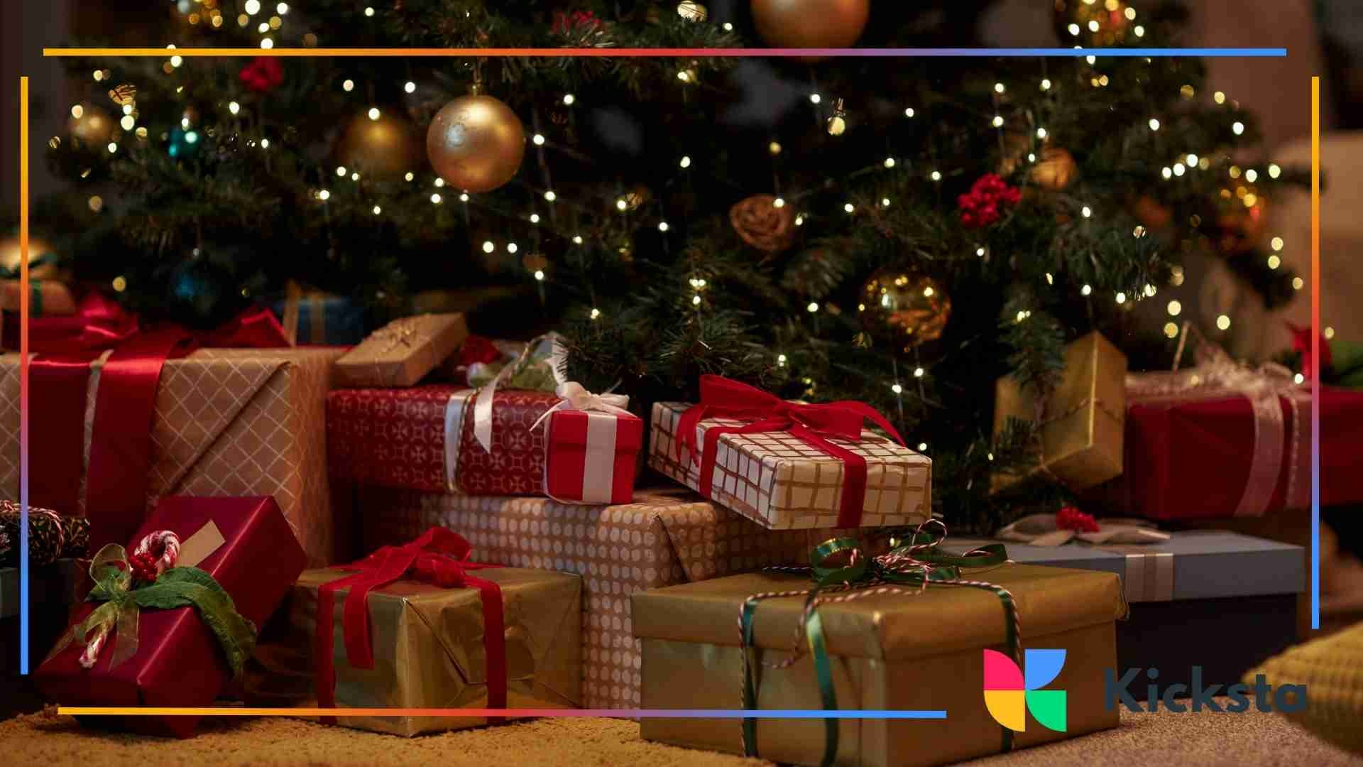 A collection of wrapped Christmas presents arranged under a decorated tree with glowing string lights.