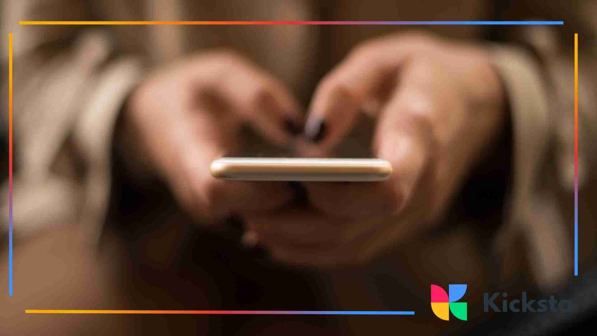 Blurry close-up of hands typing on a smartphone.