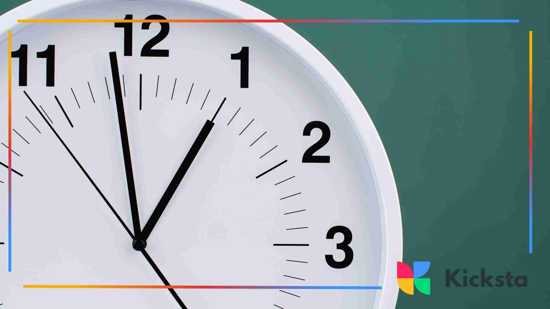 A close-up of a white wall clock showing the time just after 11 o’clock, with black hour markers and hands.