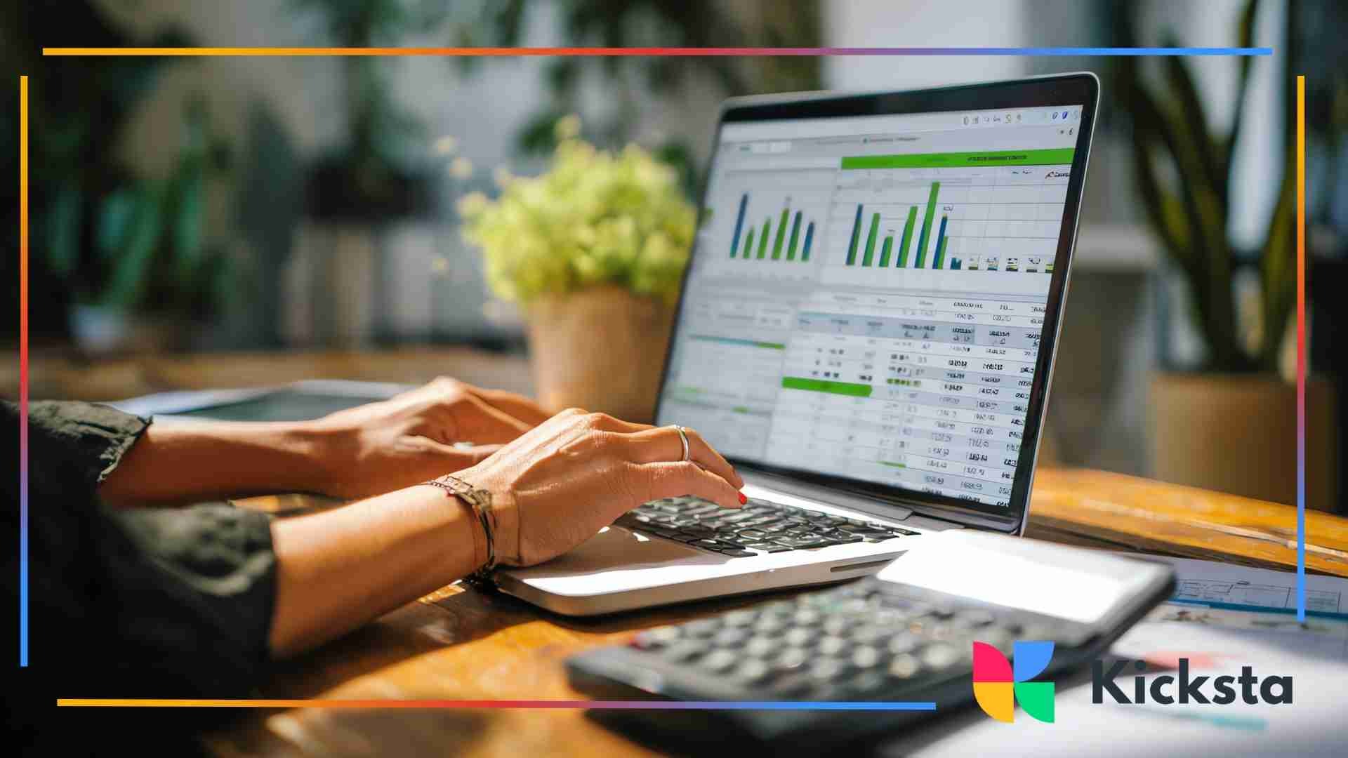 Close-up of hands typing on a laptop displaying charts, graphs, and spreadsheets on the screen.