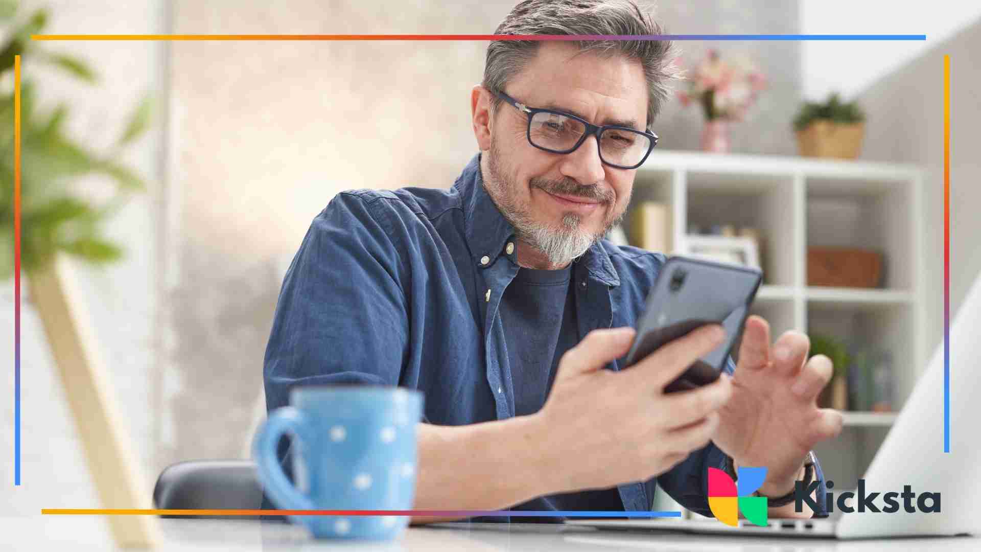 Smiling man holding a phone in his hand.