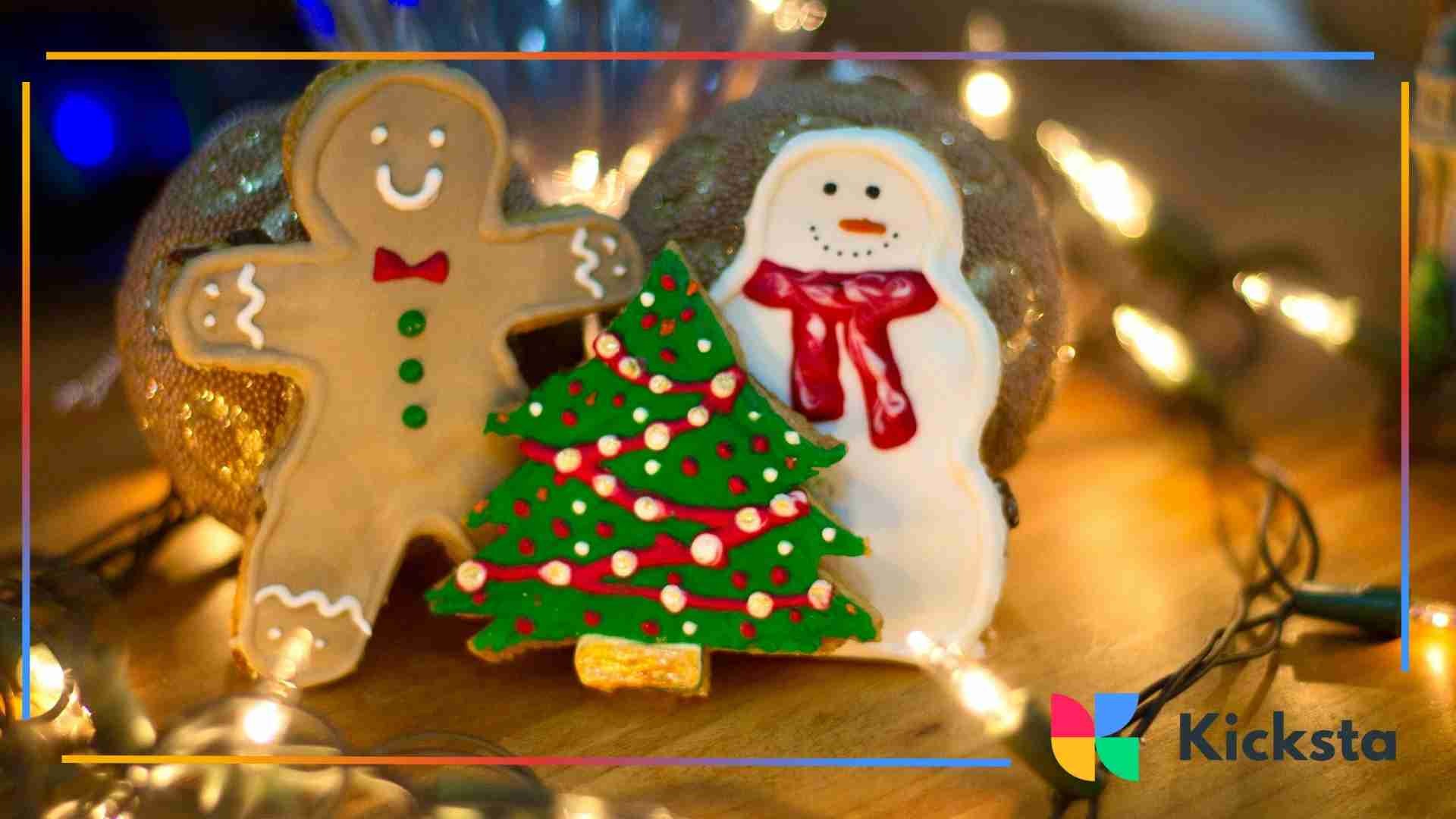 Decorated Christmas cookies shaped like a gingerbread figure, snowman, and tree displayed with warm holiday string lights.
