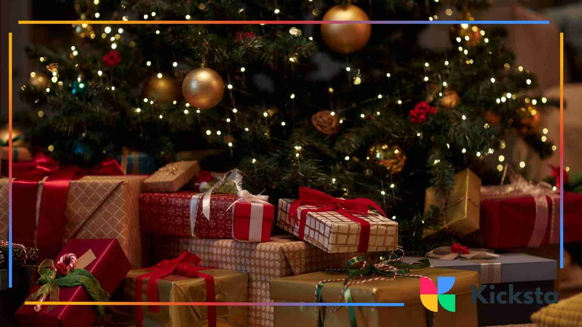 Wrapped Christmas gifts in red and gold paper arranged under a decorated tree with warm holiday lights.