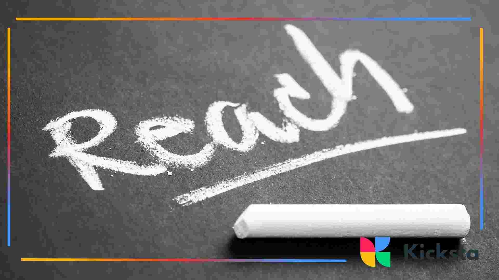 The word “Reach” written in white chalk on a dark chalkboard.