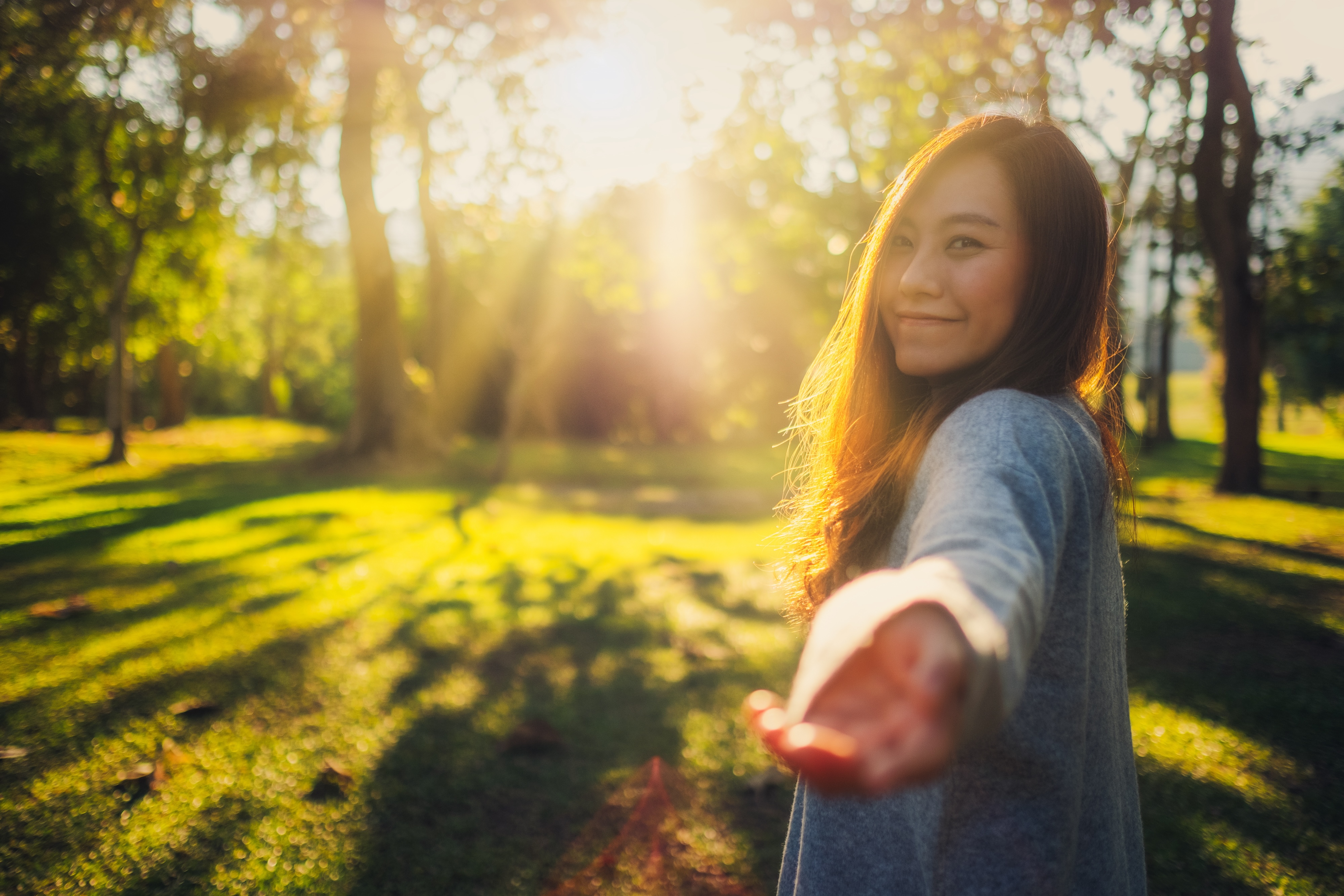 Smiling woman enjoying a walk through a sunlit park near Views at the Peak apartments in Phoenix, Arizona
