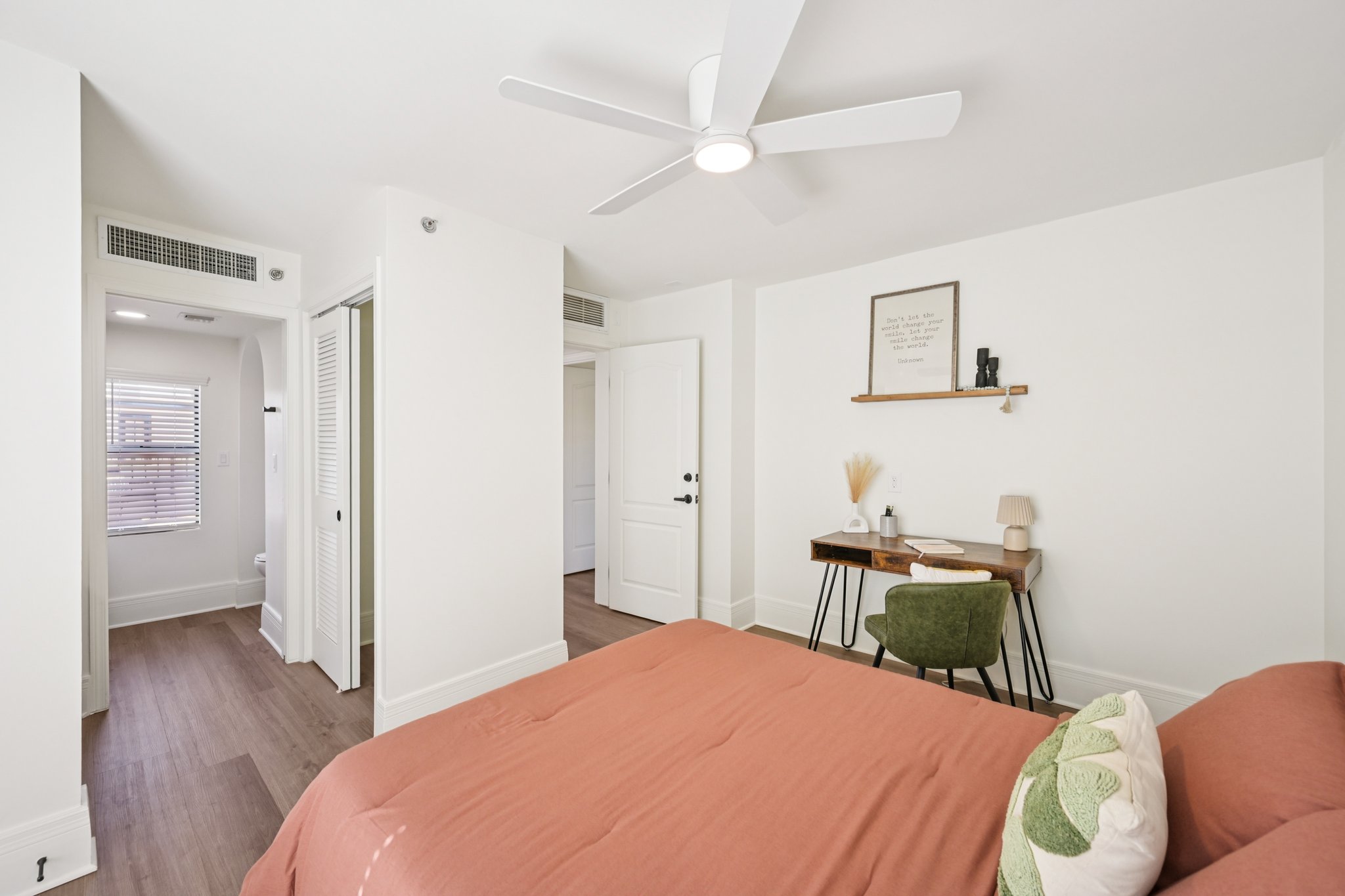 Bedroom with a bed, a desk for work or study, and a ceiling fan, in a townhome at Views at the Peak in Phoenix, AZ.