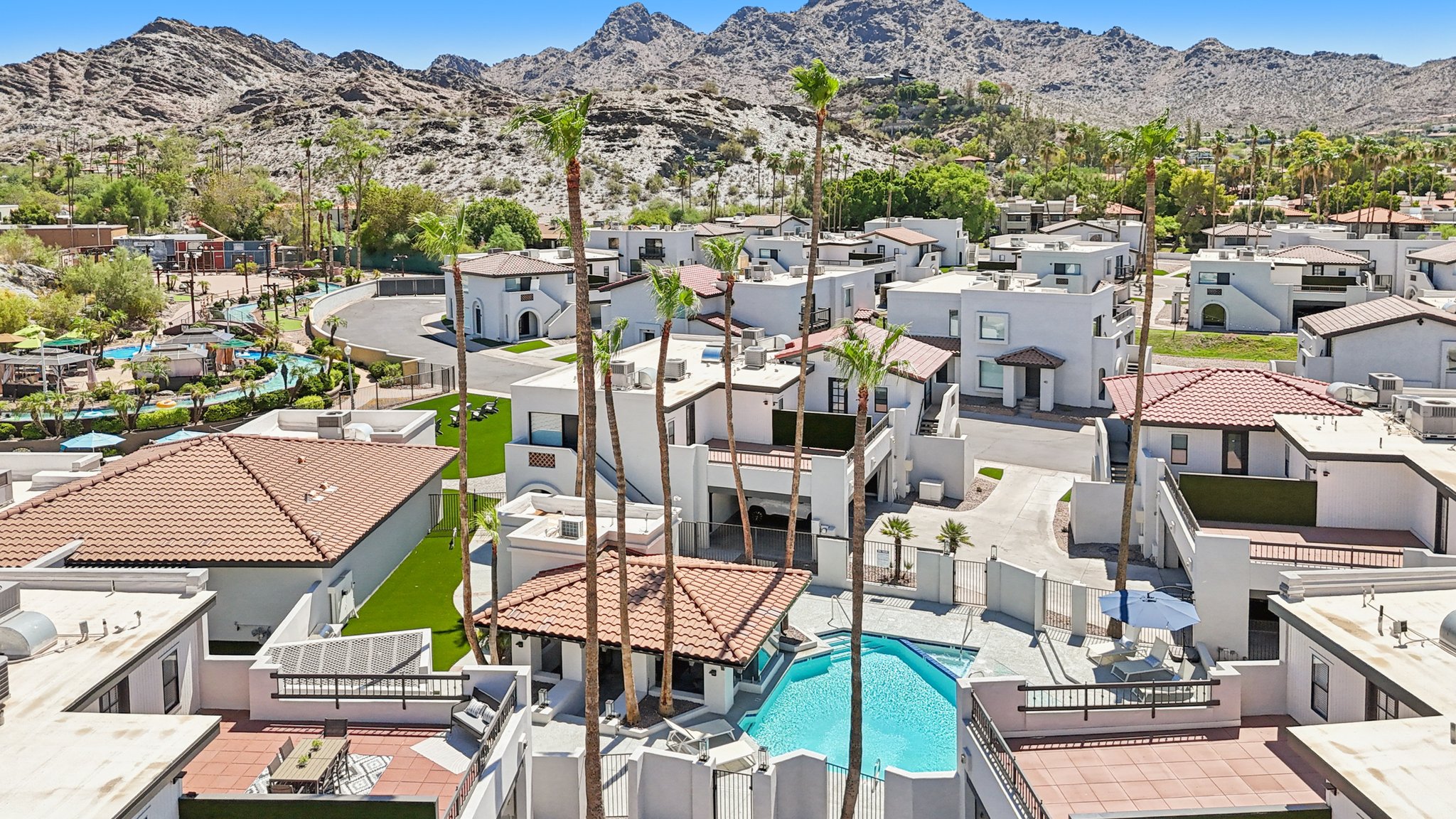 Aerial view of the resort-style pool and townhomes, set against a backdrop of desert mountains at Views at the Peak in Phoenix, AZ.