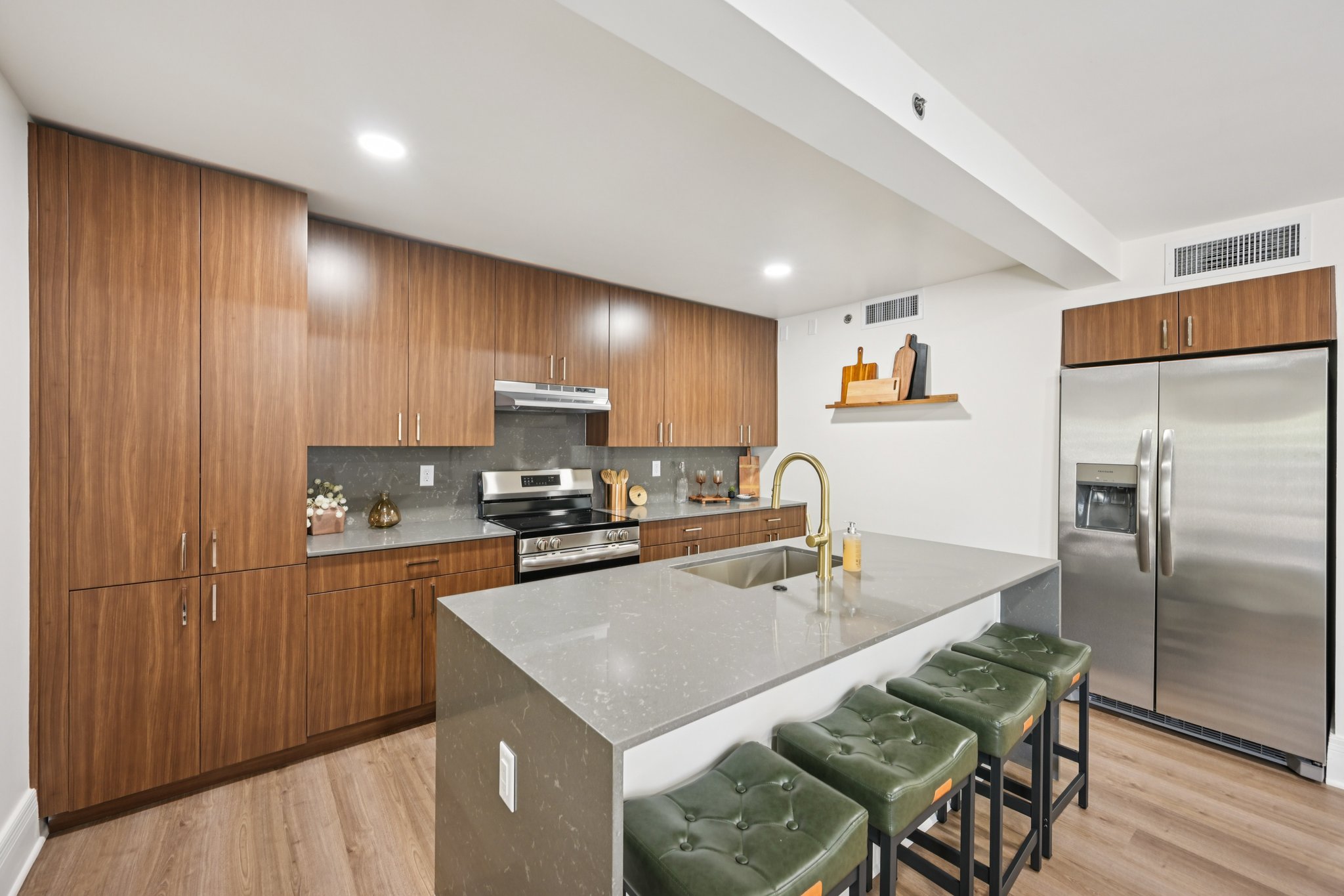 Gourmet kitchen with a large center island, wood cabinetry, and stainless steel appliances, showcasing a townhome at Views at the Peak in Phoenix, AZ.
