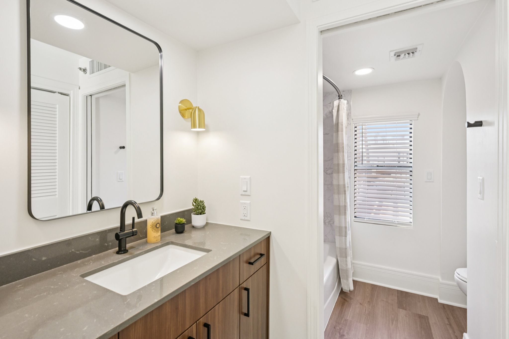 Contemporary bathroom with a single vanity, a large mirror, and a walk-in shower/tub combination in a townhome at Views at the Peak in Phoenix, AZ.