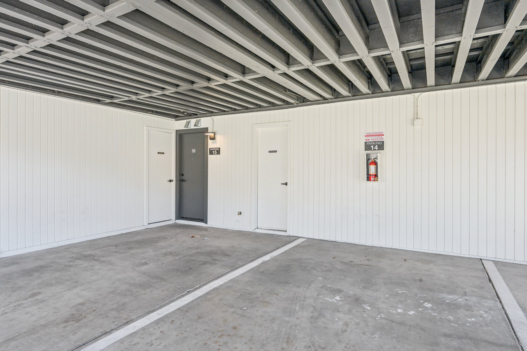 Covered parking area with designated spaces and individual townhome entrances, offering convenient access at Views at the Peak in Phoenix, AZ.