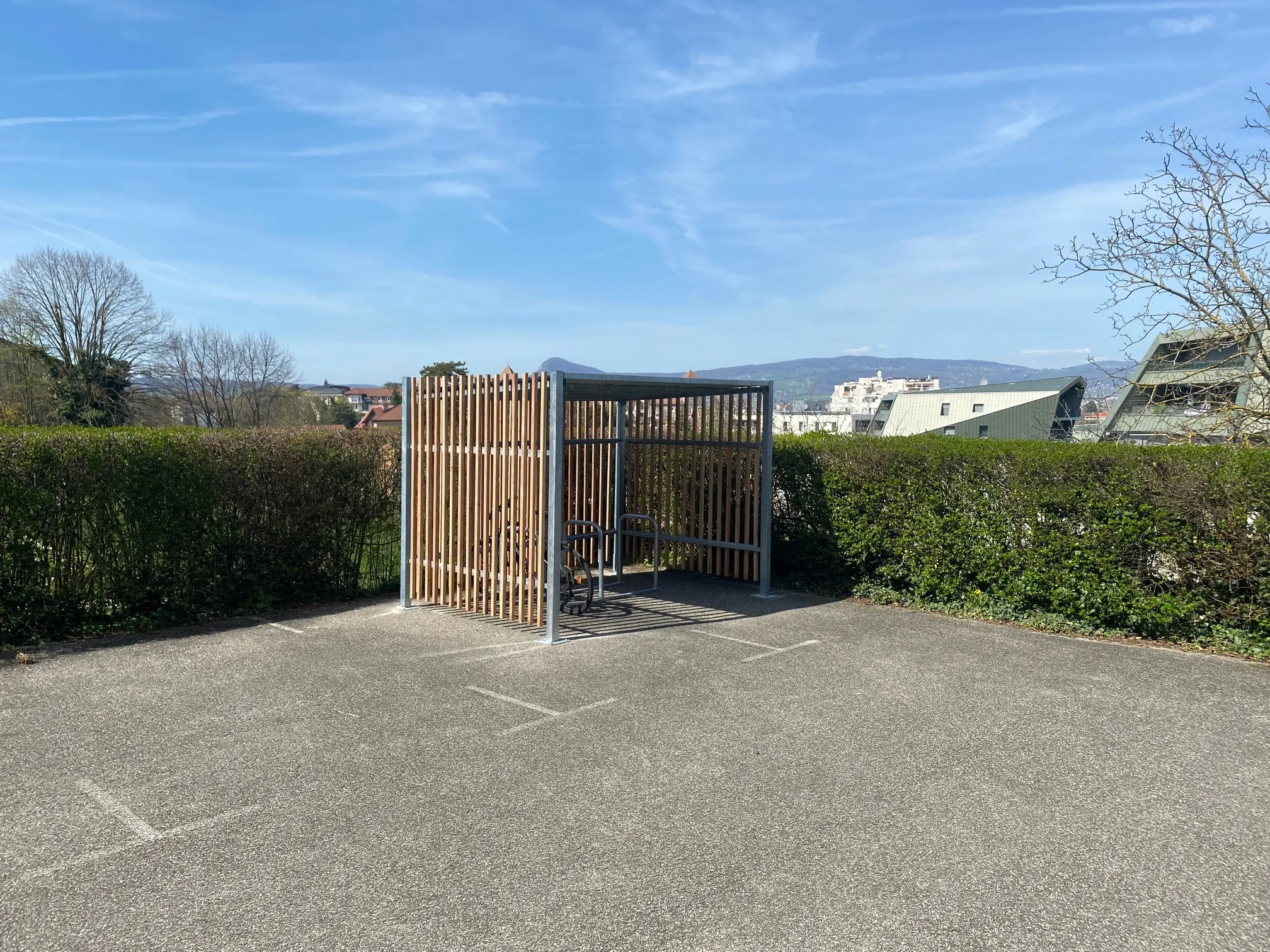 Abri vélo extérieur Axinov avec bardage bois installé sur le parking de l'Évêché d'Annecy