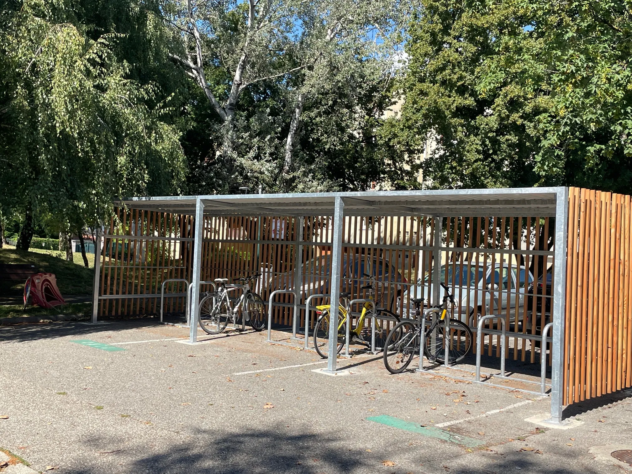Abri vélo extérieur avec bardage bois et vélos stationnés, installé à Fontaine en Isère