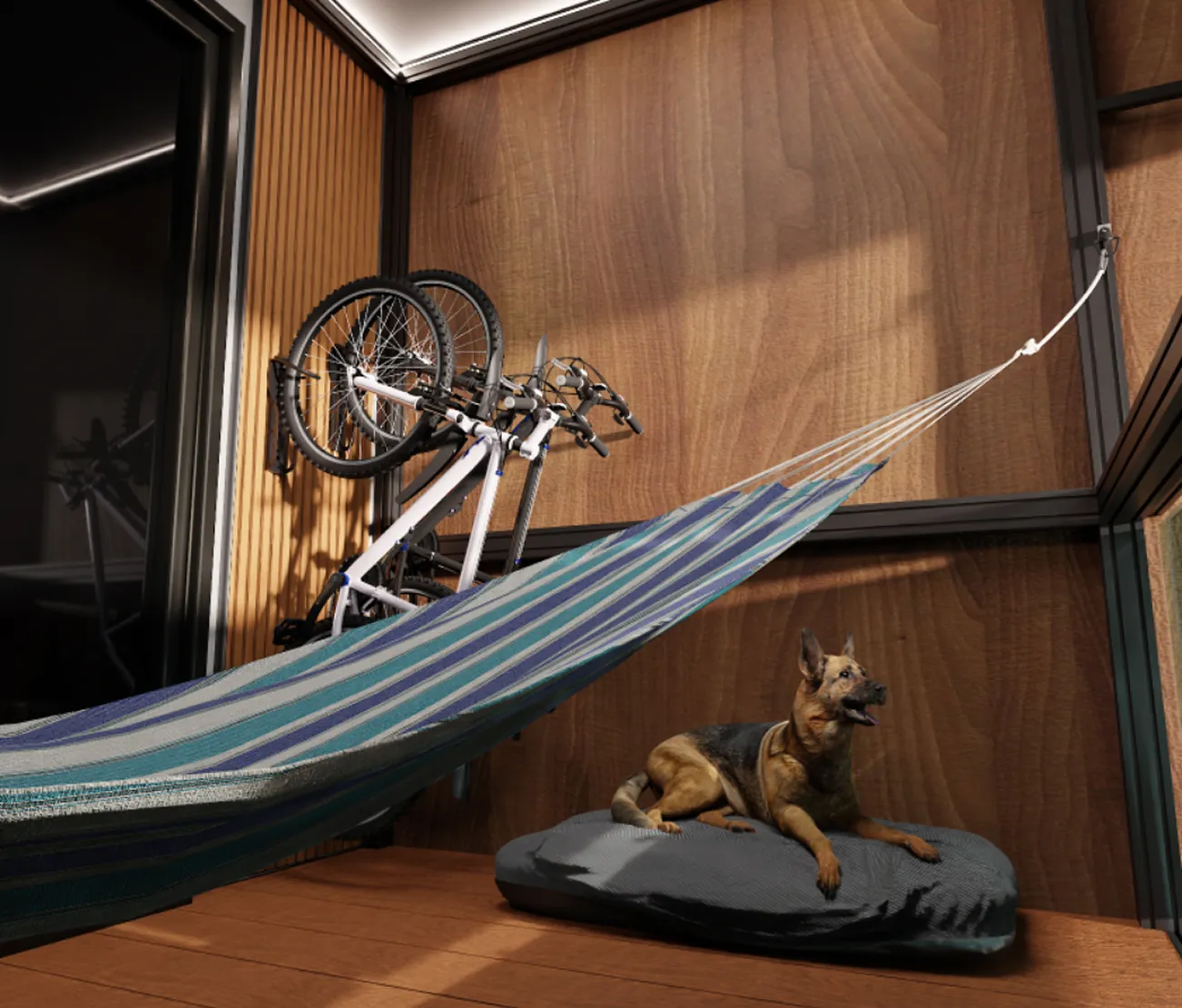 German shepherd dog lying on a gray cushion next to a blue and green striped hammock indoors with two bicycles mounted on a wooden-paneled wall.